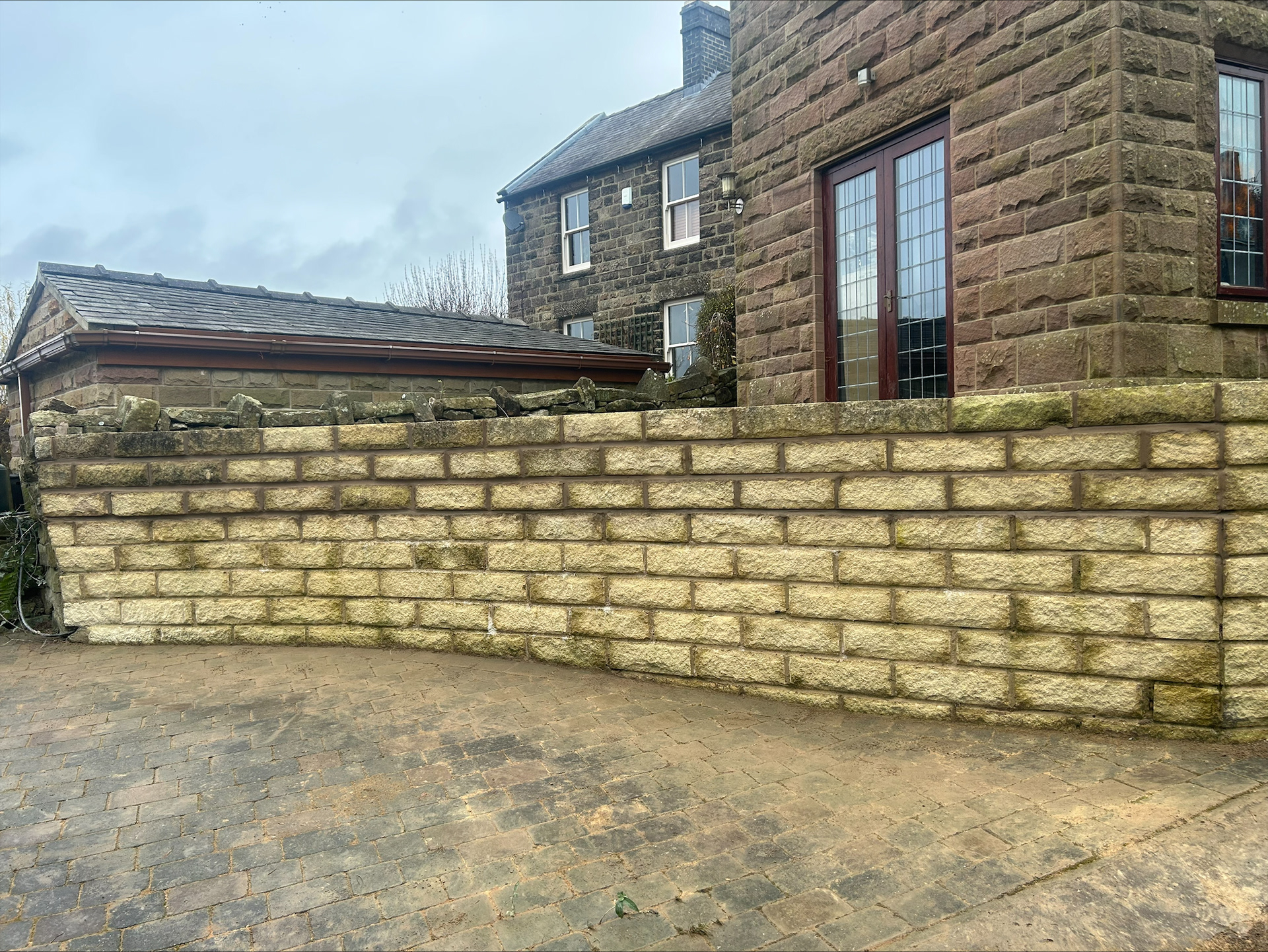 Re-lay top few courses of retaining wall