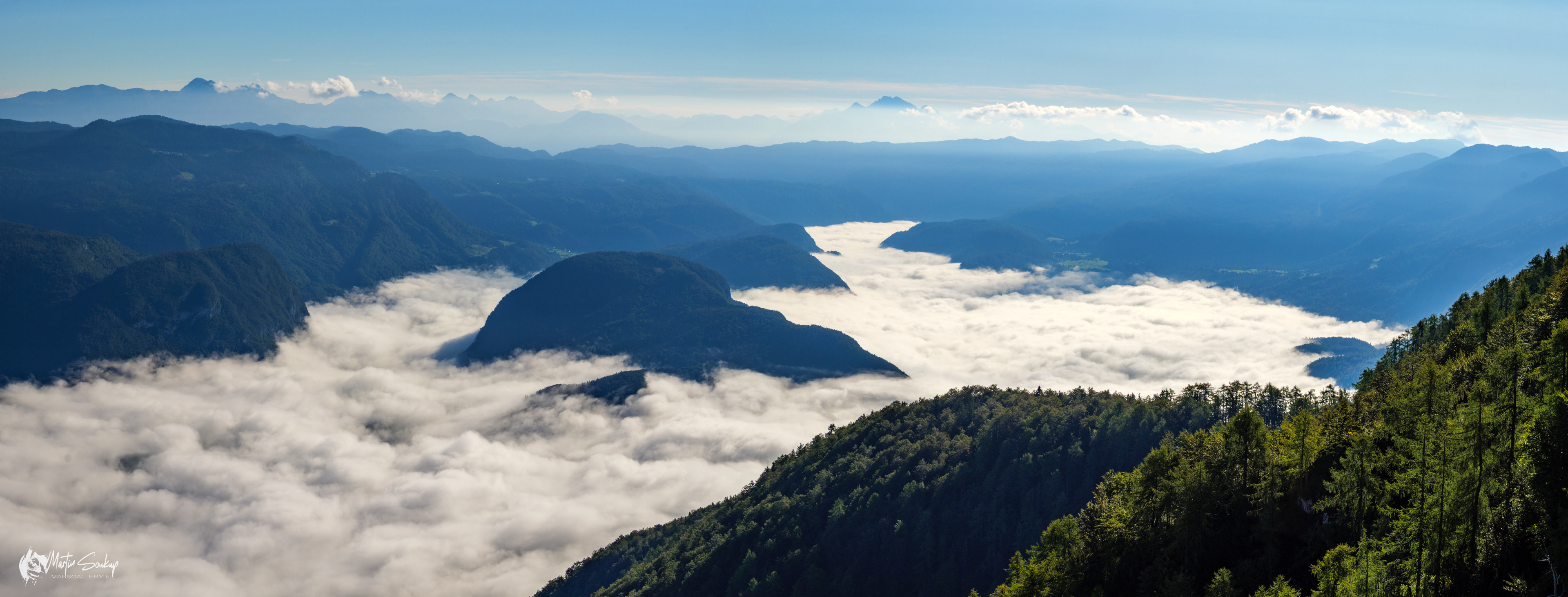 Pohled na jezero Bohinj schované pod ranní mlhou