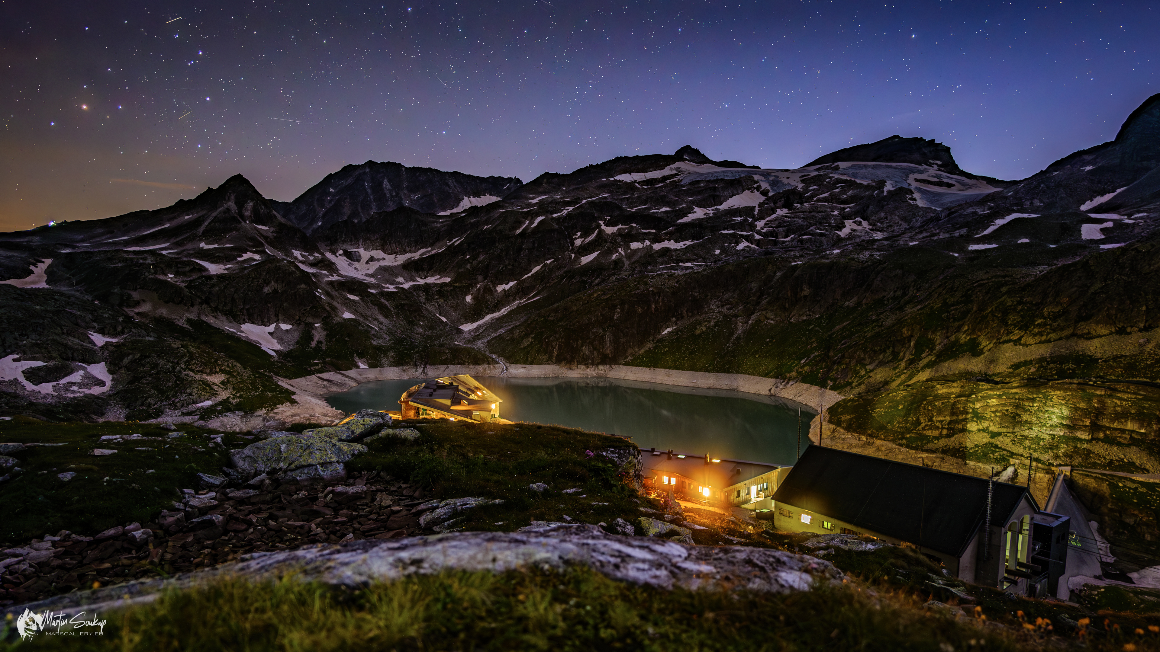 Jezero Weißsee spolu Berghotelem Rudolfshütte a lanovkou v pozdní večer z hory Hinterer Schafbichl