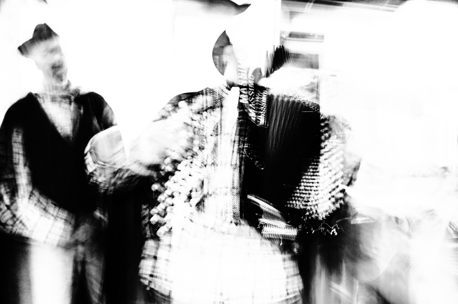 La Pasquella (2025) Due figure emergono dal mosso, cantano la Pasquella come se il tempo si piegasse al rito. I volti sfumano, ma la voce resta: vibra nell’aria, nell’eco dell’organetto. È tradizione che si fa immagine, canto che attraversa il corpo. I pasqualotti danzano tra luce e memoria, vivi nel gesto.