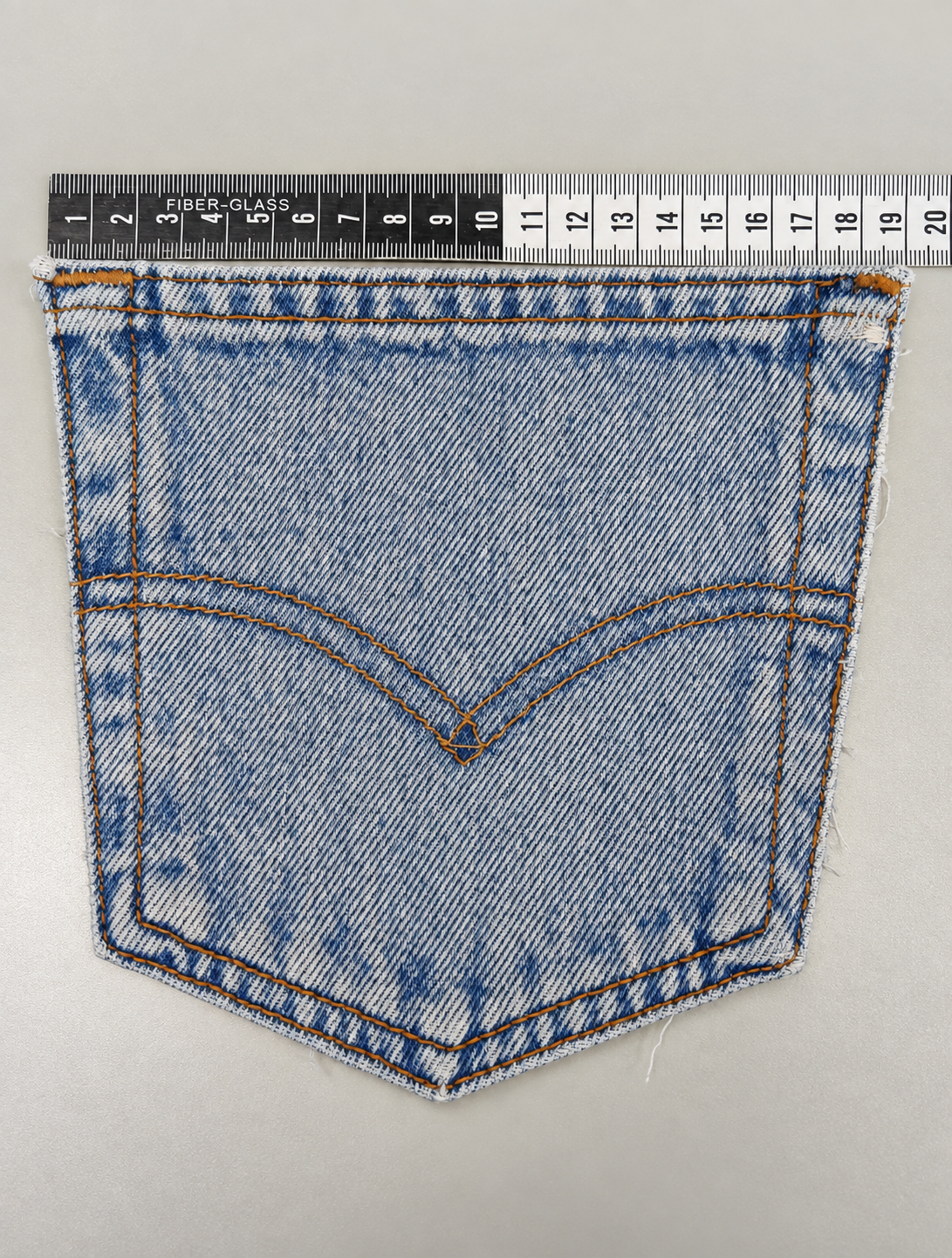 Measuring the physical denim pocket to establish a reference for accuracy.