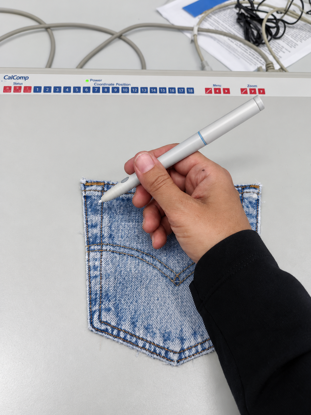 Tracing the outline of a deconstructed denim pocket on the digitising tablet.