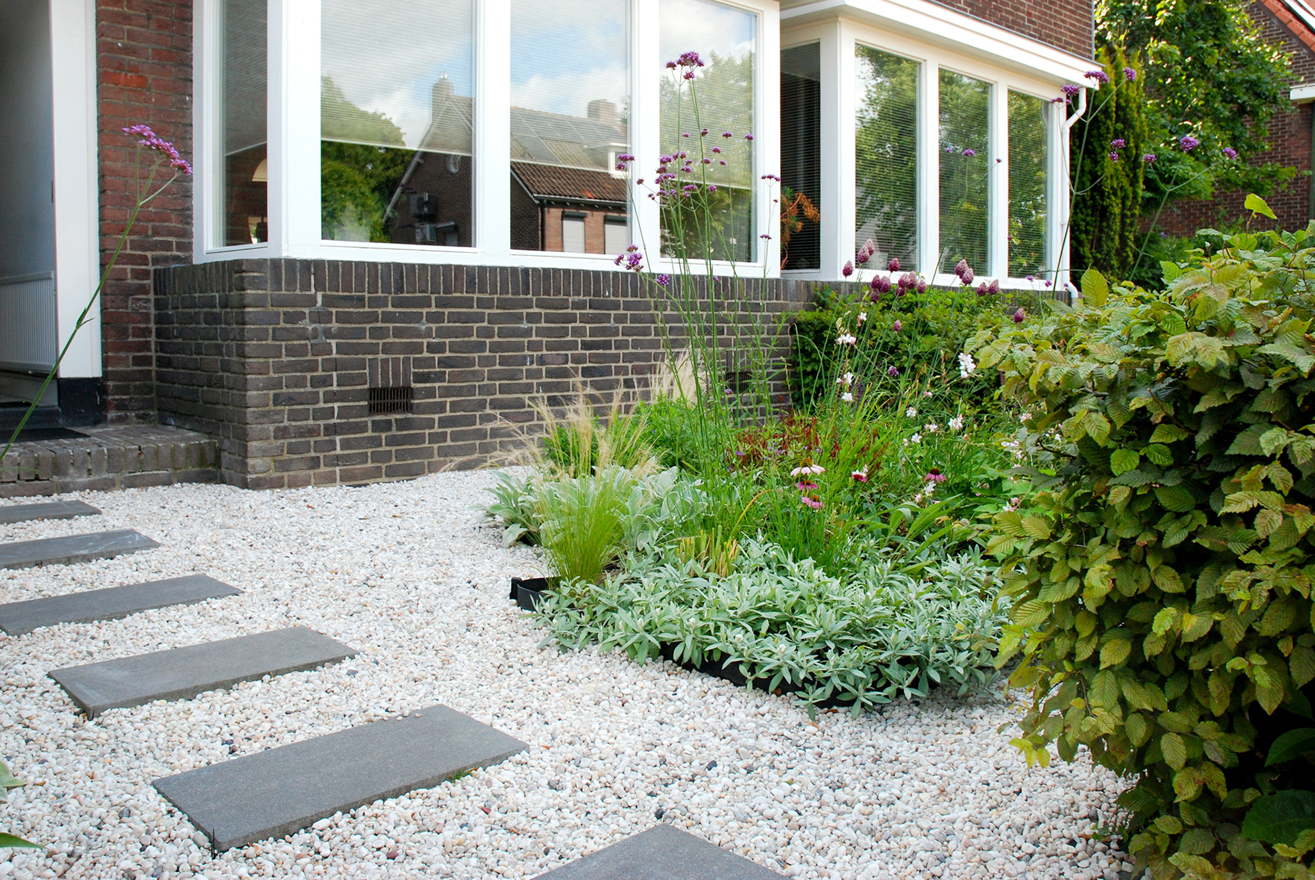 Voortuin met grind, stapstenen en plantvak