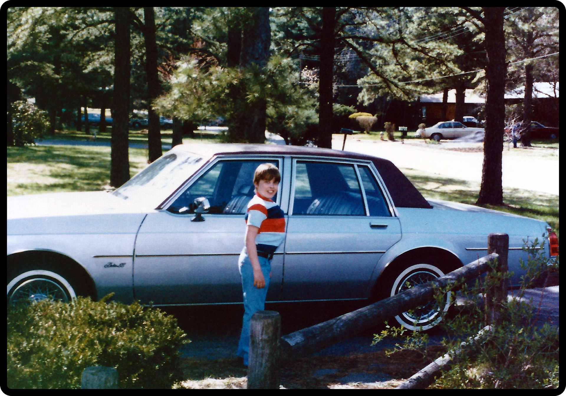 Gregory in front of somebody's 1970's oldsmobile
