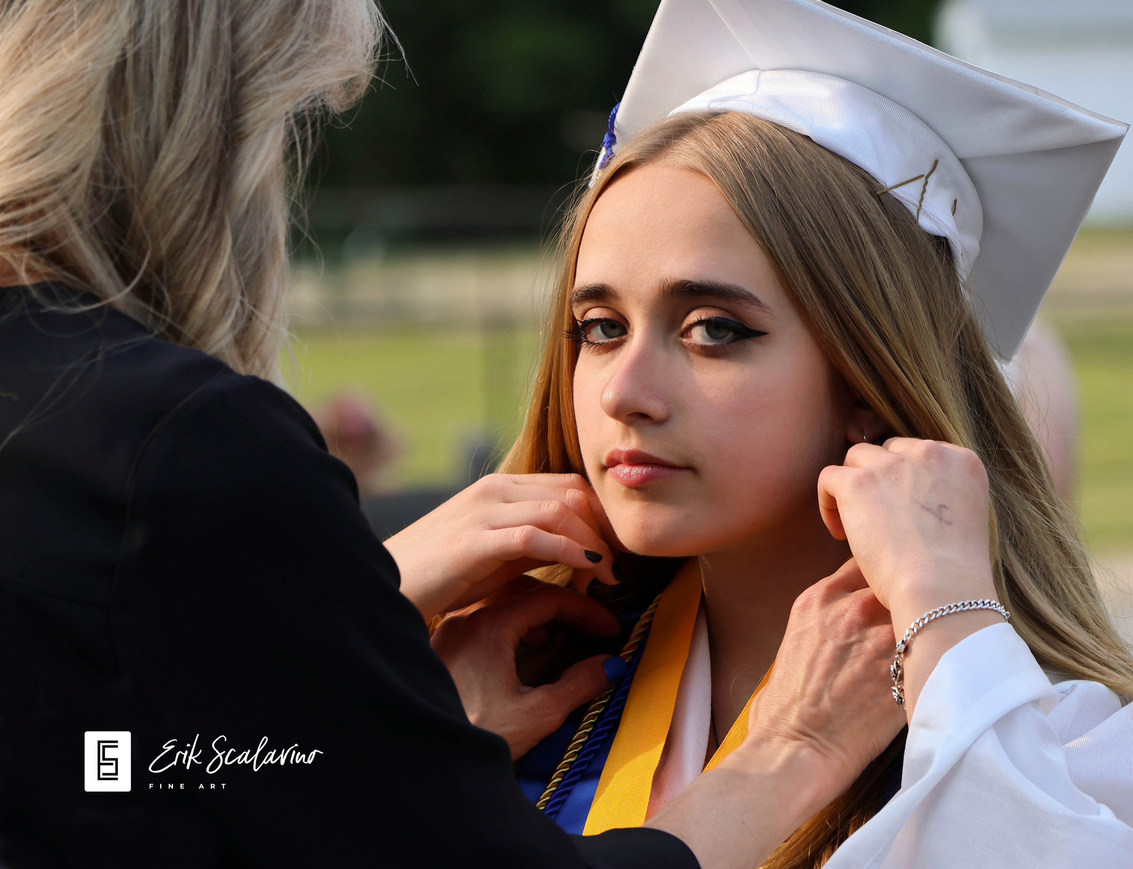 Graduating high school senior gets last-minute wardrobe adjustments from her mom.