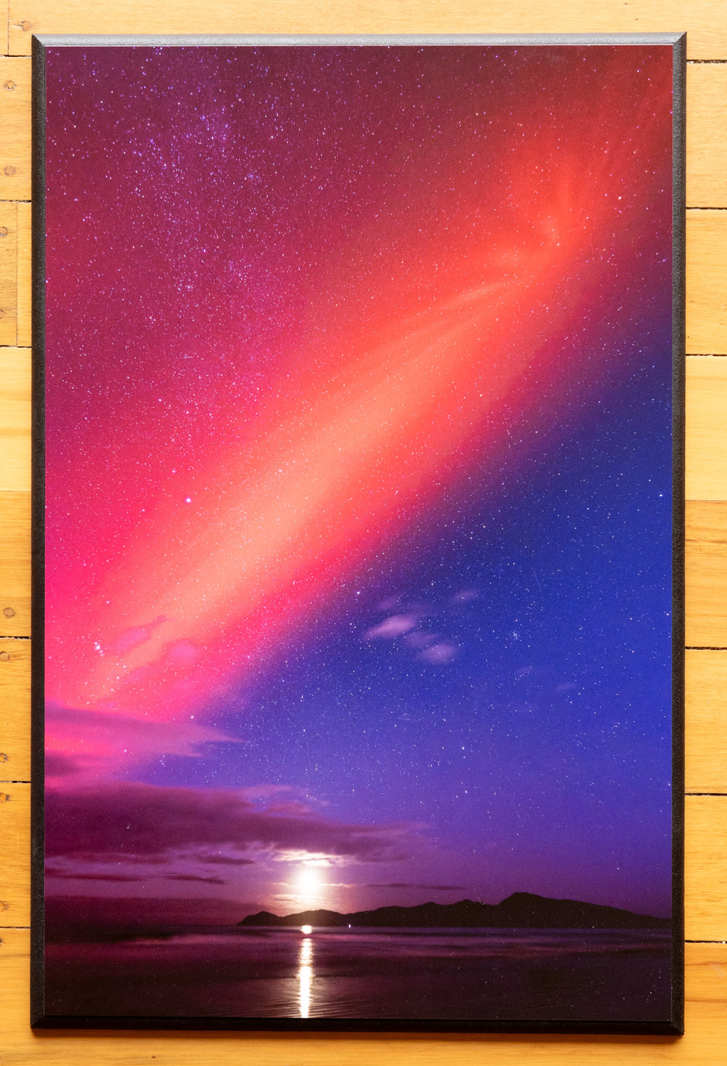 Kapiti Island aurora. The aurora of 11 May 2024 reached north of Kapiti Island and coincided with a setting crescent moon. I reduced the saturation of the print as it was too gaudy out of the camera!