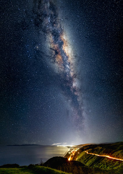 Milky Way over Kāpiti: We are fortunate to have relatively dark skies over Kāpiti, that give us views of the night sky not seen by most people in the world. Here the Milky Way reaches north over the Kāpiti Coast. A car illuminates the road to the Paekākāriki Hill lookout.