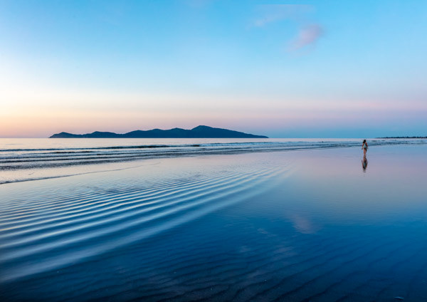    Kāpiti Island in the blue hour: A girl contemplates reflections in the hour after sunset