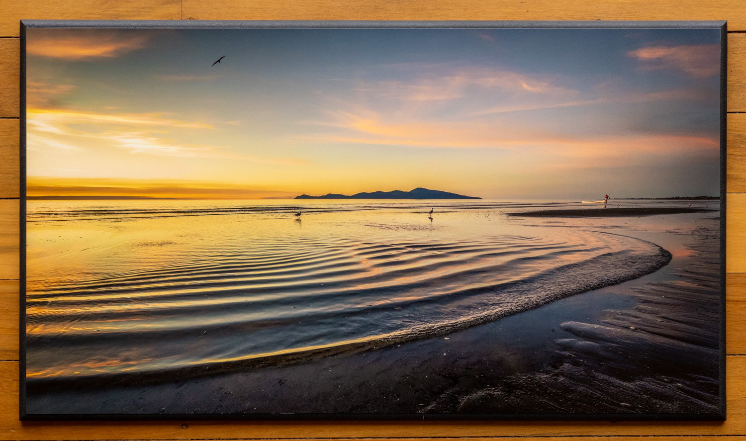 Kapiti paddler - The end of a beautiful day as a paddler hauls their kayak out of the water and gentle waves ripple over the shore