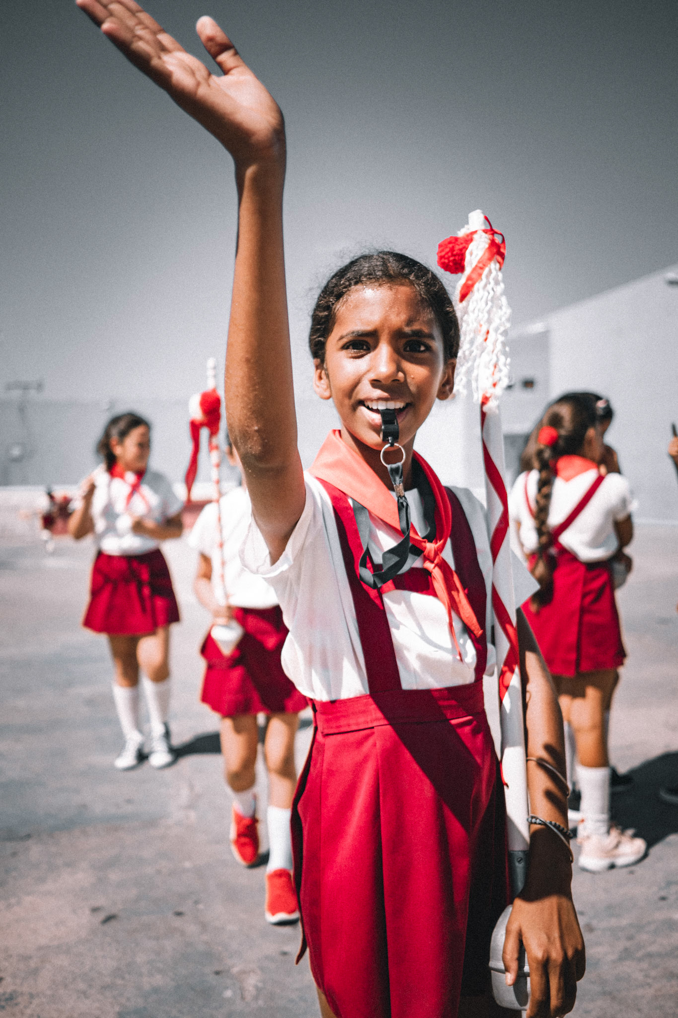 Jamais auparavant je n’avais été remis à ma place de manière aussi autoritaire et sans que je puisse y trouver à redire. Cette jeune fille était en charge de la coordination de la cérémonie du 1er mai à Trinidad de Cuba et je me suis approché, trop heureux de pouvoir profiter de cette chance.Au début tout se passait bien jusqu’à ce qu’un jeune tambour ne se prenne au jeu et commence à se la jouer perso. Il faut dire qu’il attirait très naturellementles regards du fait d’un charisme hors norme. N’appréciant que très modérément la situation, cette jeune meneuse de troupe essaya de le recadrer plusieurs fois sans succès. La jeune meneuse se dirigea alors vers moi et me fit comprendre que j’étais de trop et qu’il était temps que je m’en aille. Le tout sans aucune menace mais avec une telle autorité et une prestance naturelle que je me suis senti immédiatement tout miséreux et pris rapidement mes distances pour ne plus interférer.