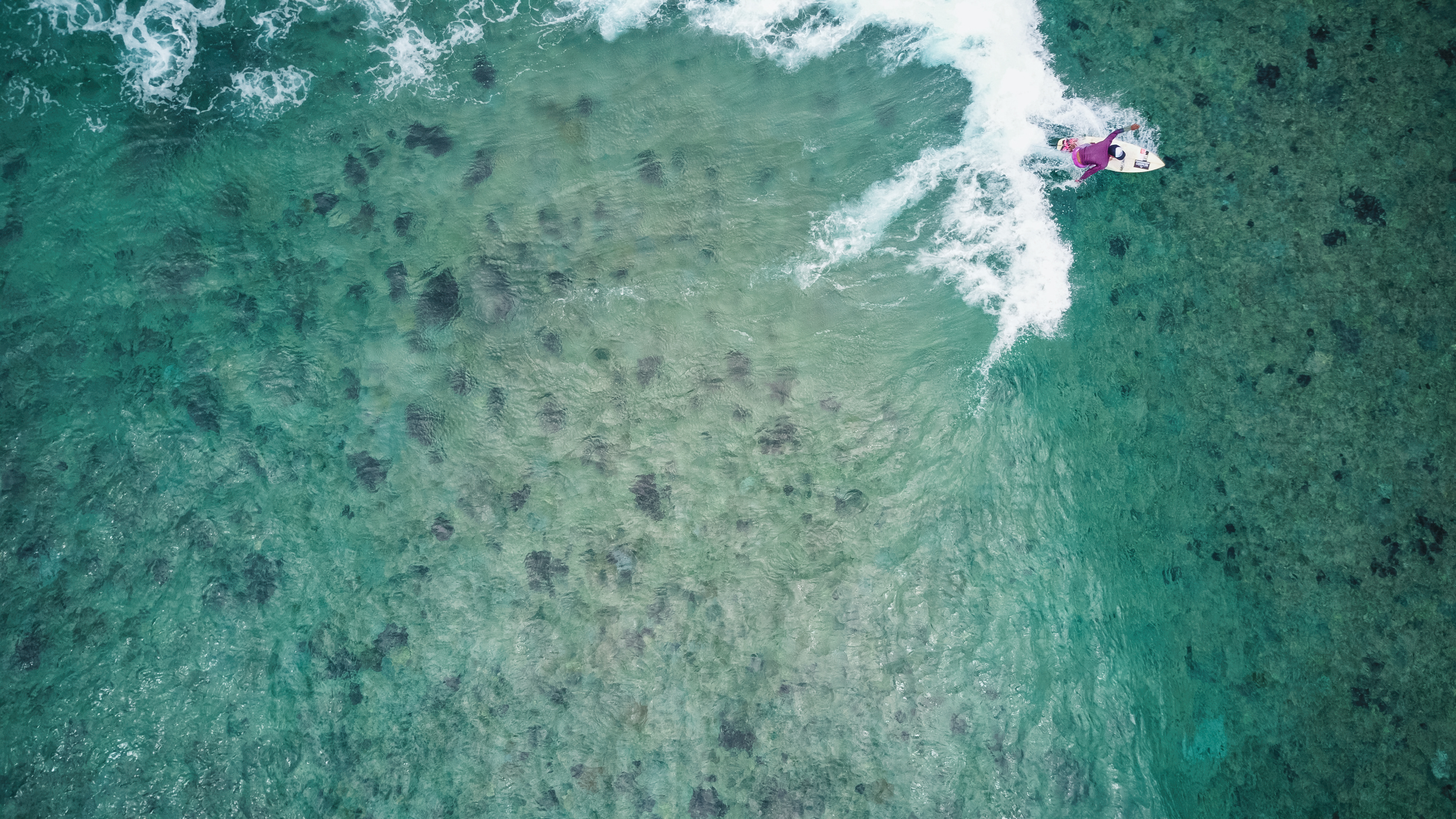 Top-down aerial photography print of a surfer catching a wave