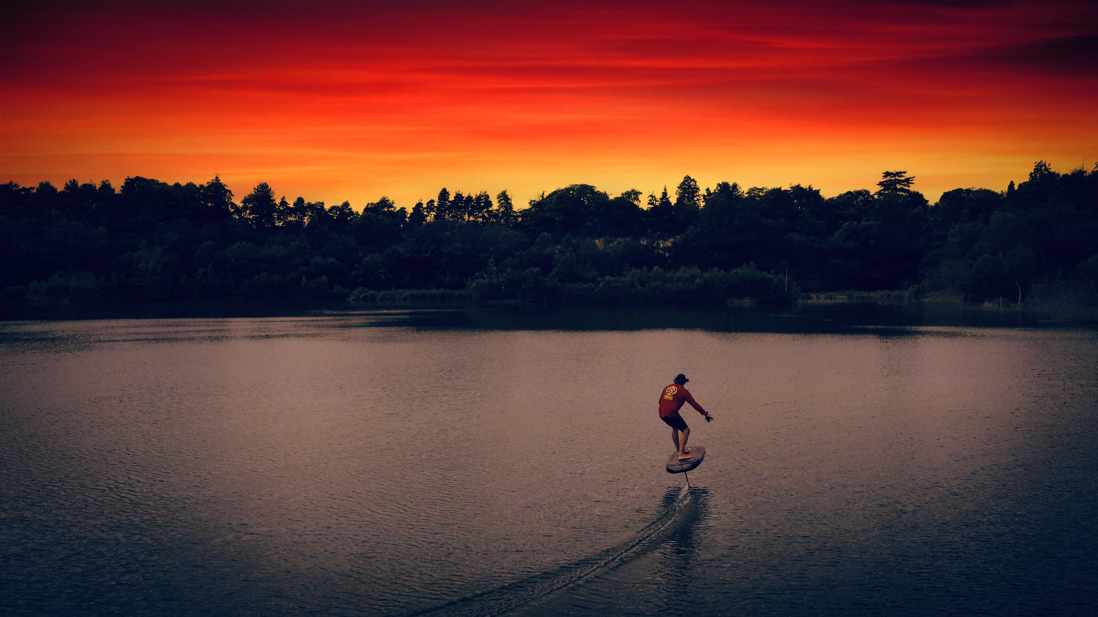 Aerial photography print of a man eFoiling into the sunset of Buckland Park Lake in Surrey