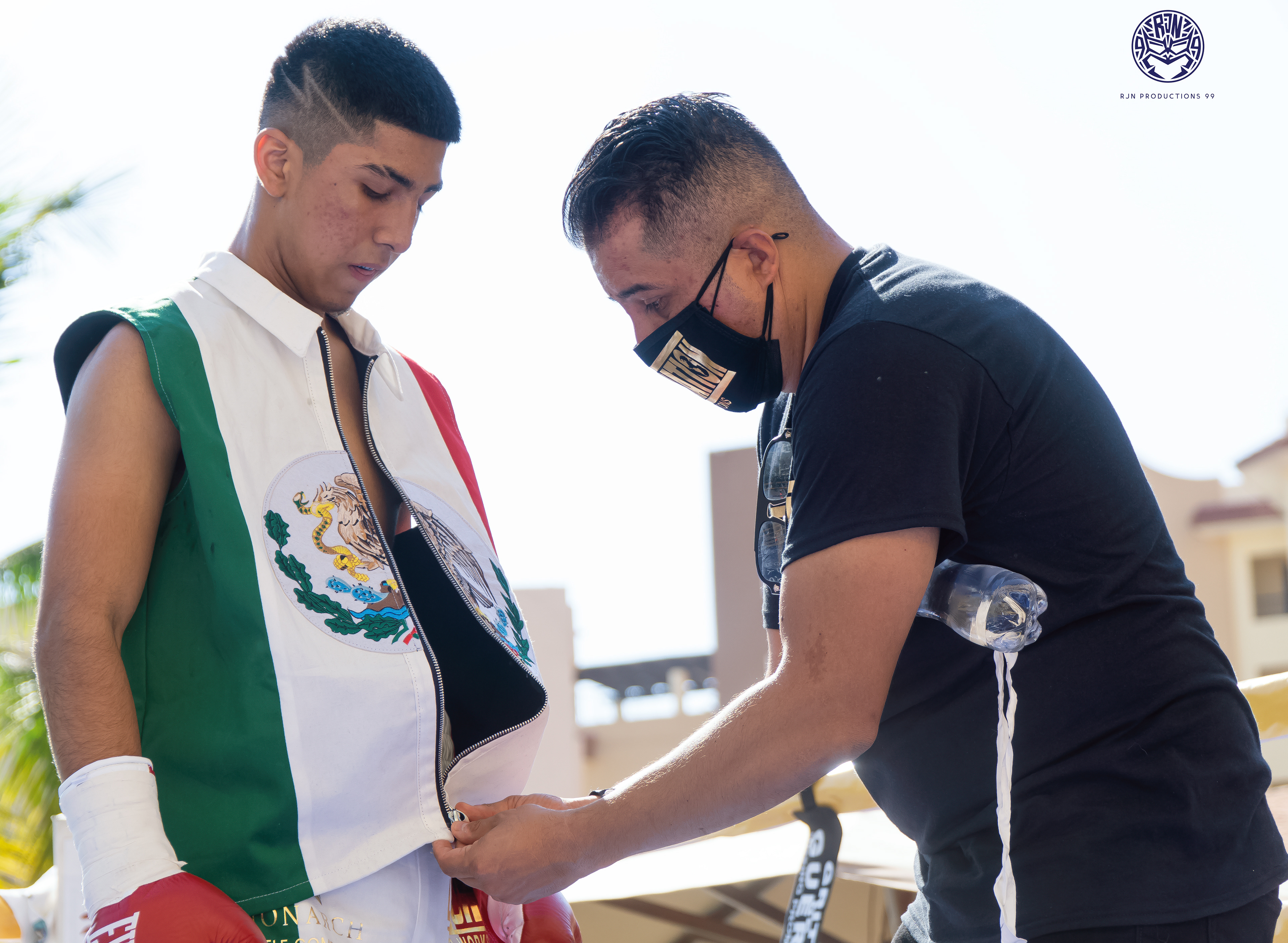 Promoter Marvin Rodriguez zipping up Nathan Rodriguez's vest