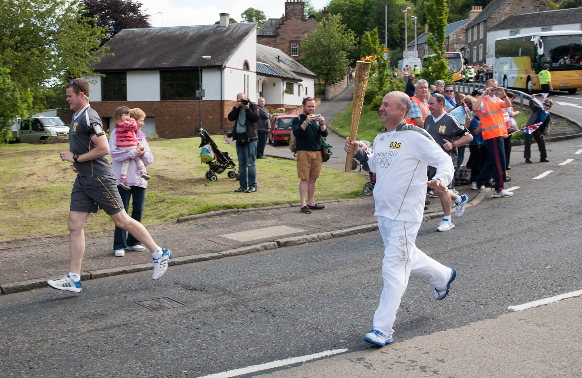 Ivor Mathers carries the Olympic torch through Lasswade, Midlothian, 2012