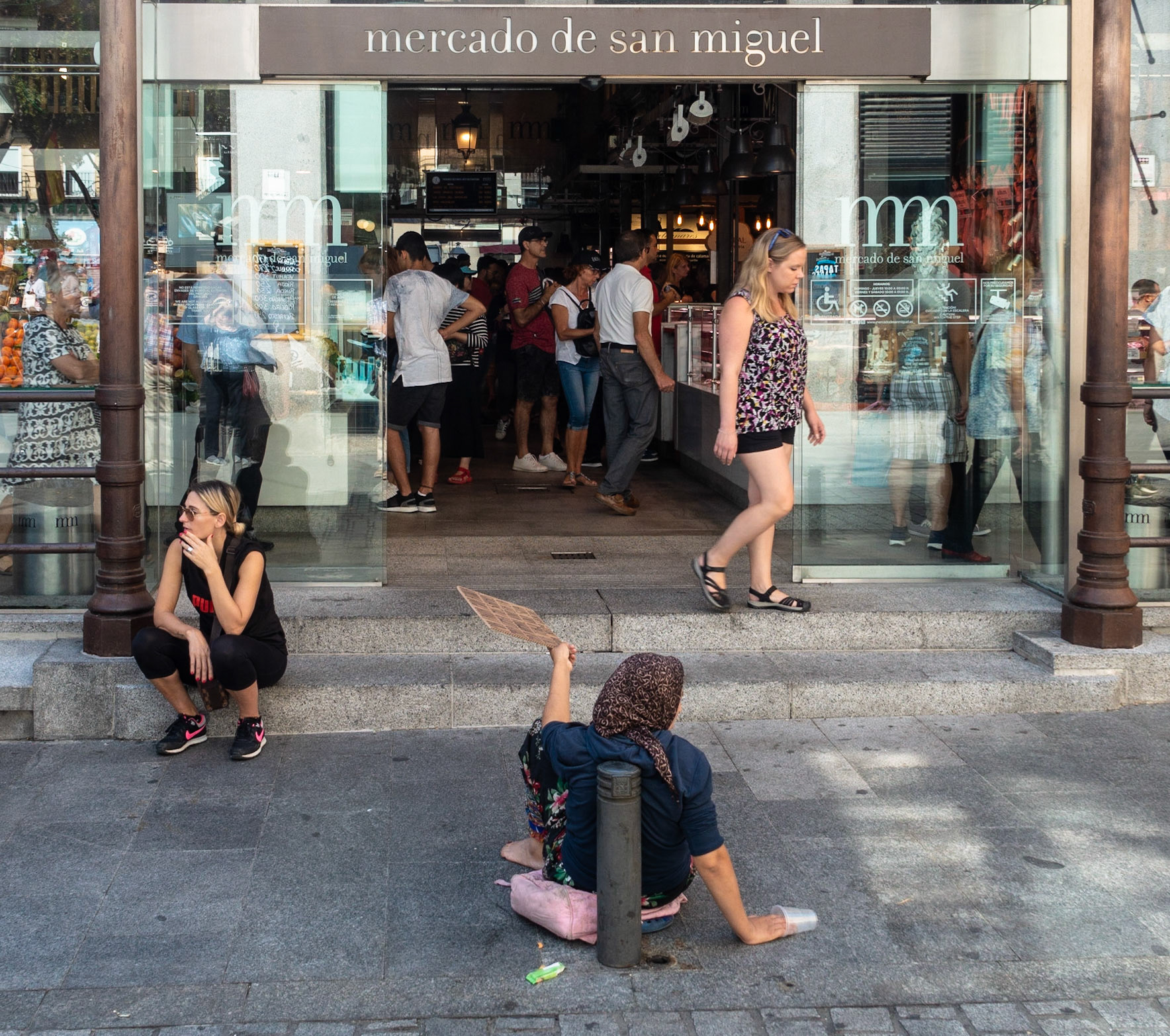 Beggar outside San Miguel Market, Madrid, 2018