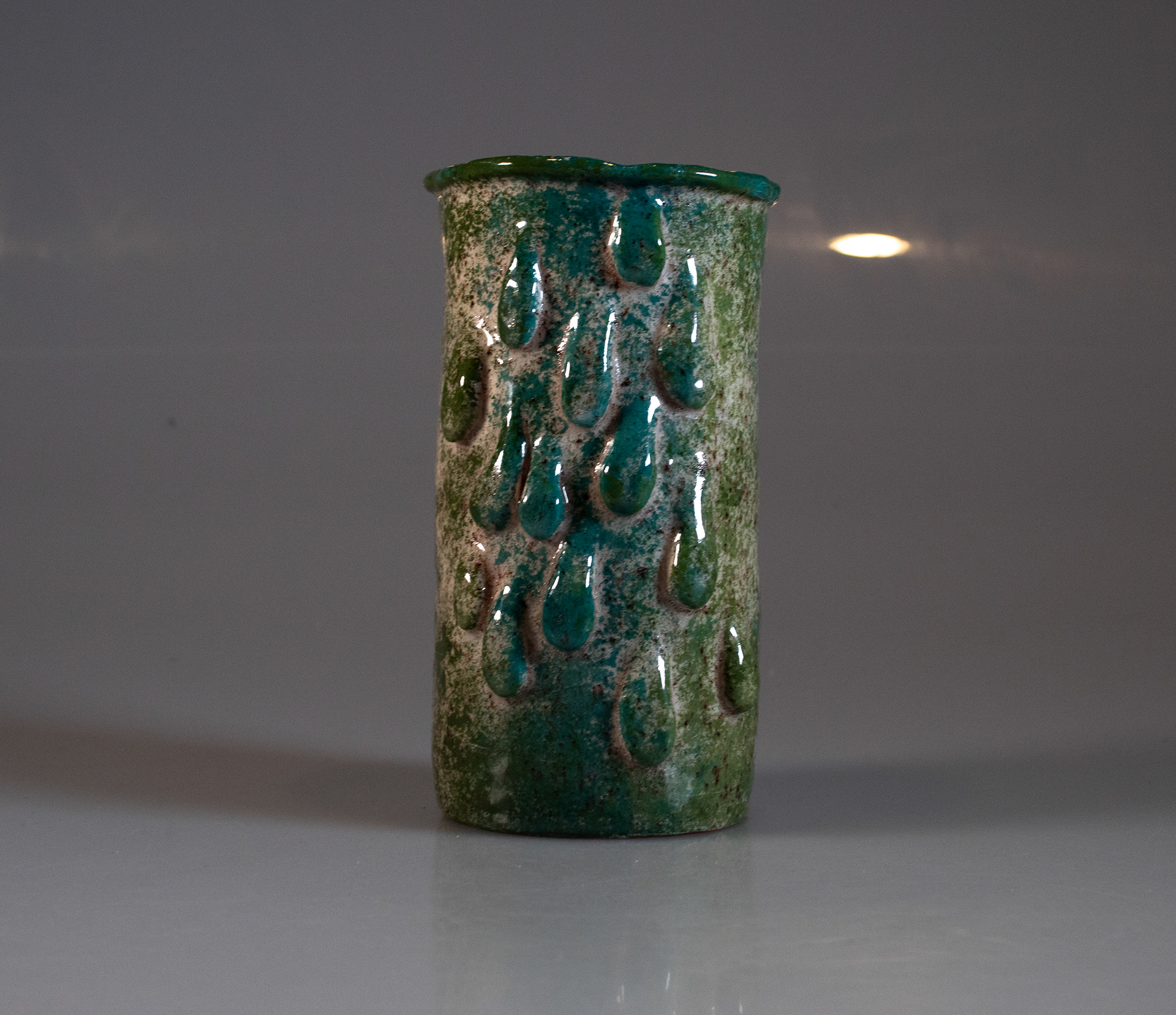 "Untitled", Ceramic, 7.5 x 4.5, 2025 |  This piece is part of a three-part series that addresses the effects of coral bleaching caused by ocean acidification. All three pieces are terracotta clay with speckled slip and sponged on underglaze. This piece is followed by another pot as well as a ball with coral on top. 