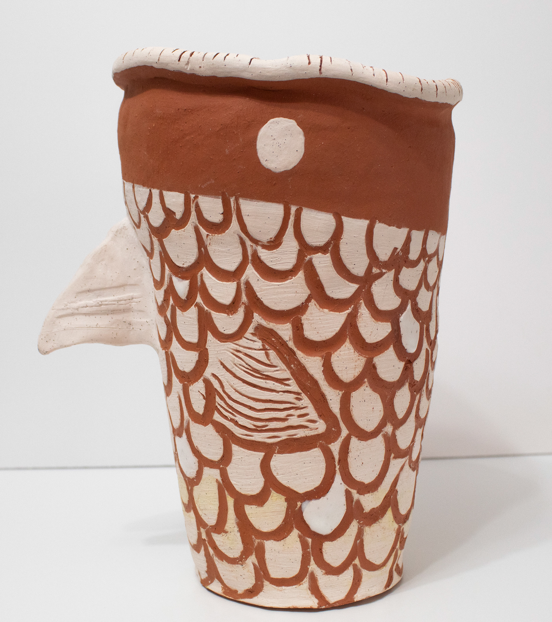 "Fred", Ceramic, 10.5 x 7, 2024 |  This piece is a terracotta pot with white slip. The scales and texture were created by using the sgraffito method.