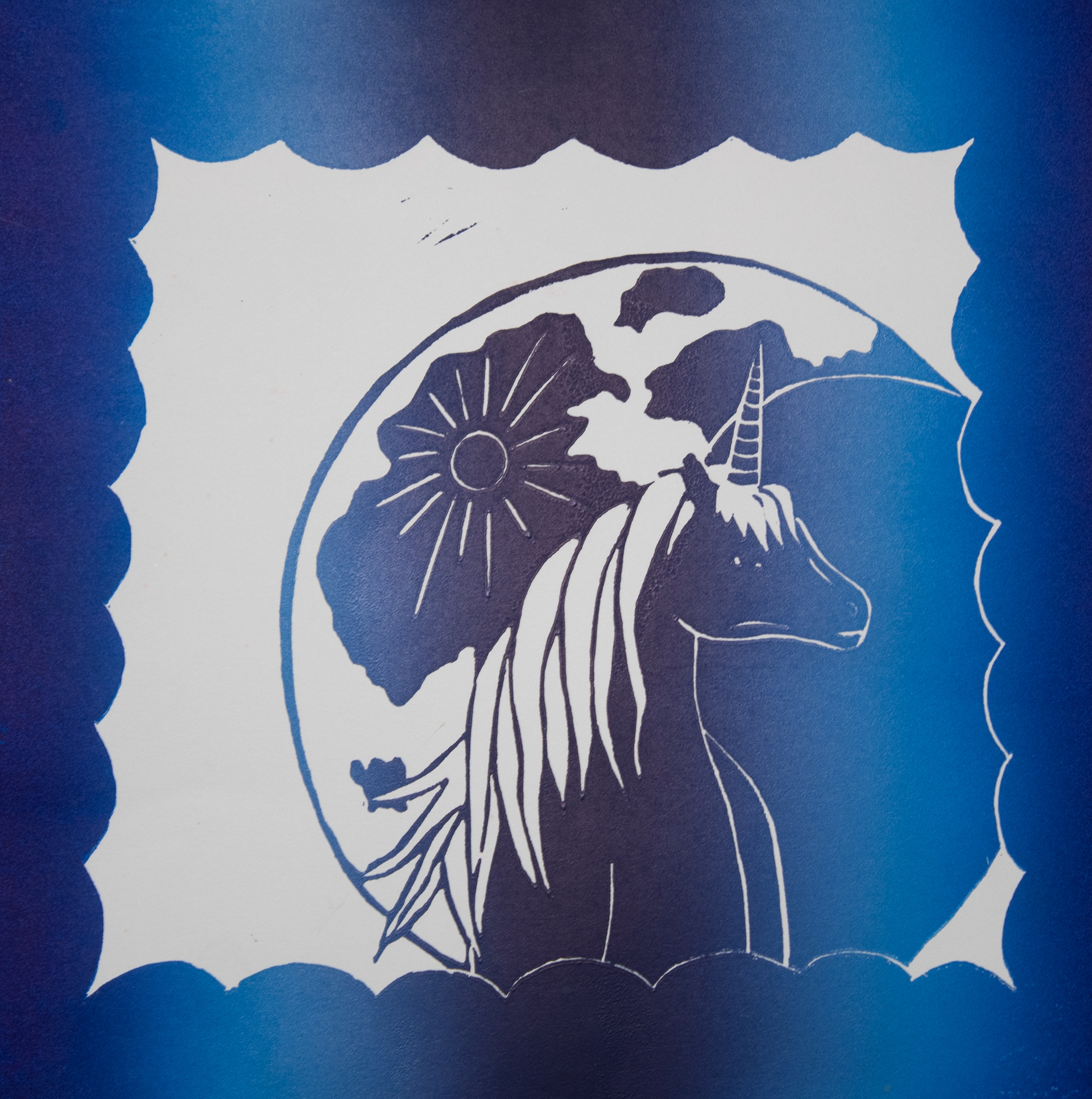 "Untitled", Printmaking, 10 x 10, 2025 |  This piece is a linoleum block print. I carved a scalloped border into the linoleum and did a rainbow roll with dark blue, light blue, and purple.