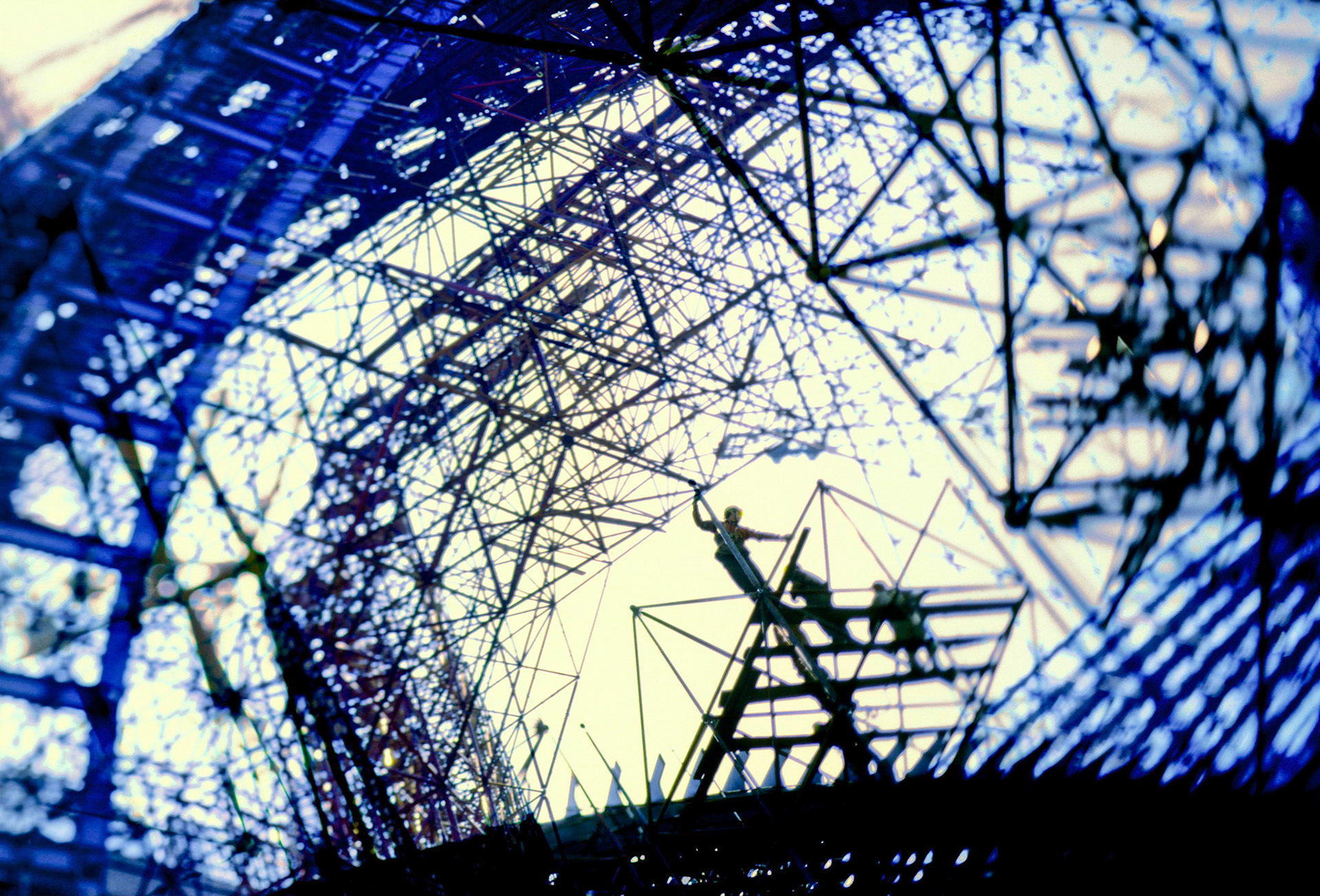 Des ouvriers élèvent les échafaudages permettant la construction du Grand Théâtre National de Chine. Paul Andreu architecte. Pékin. 2002