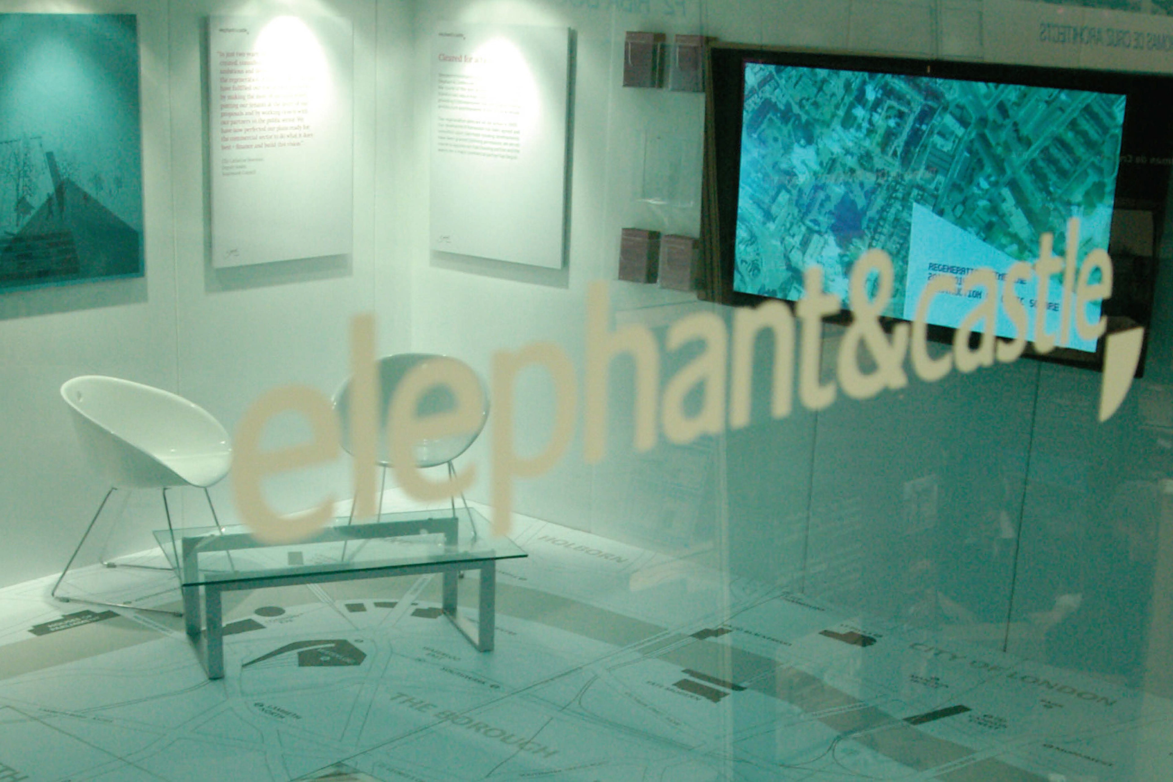 exhibition with chairs, video screen and giant map