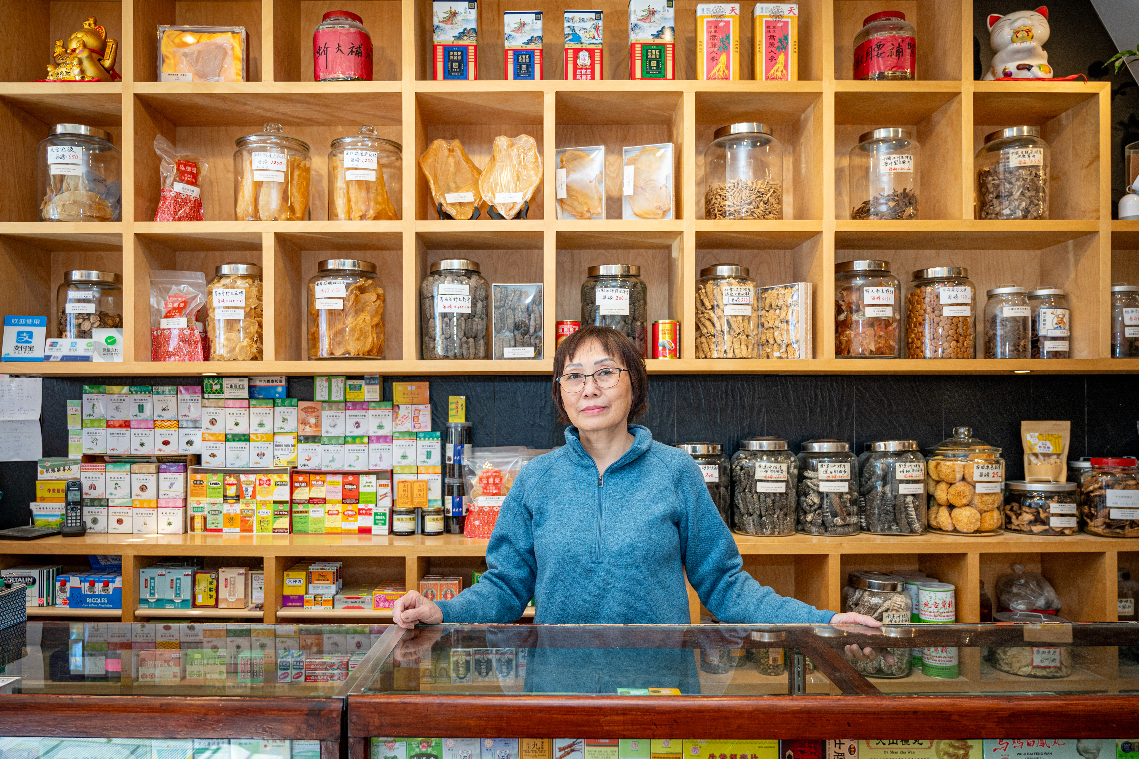 Kim Lien Phu, responsable du magasin à la caisse  Kim Lien Phu, store manager at cash register counter  門店經理符金蓮在收銀櫃台