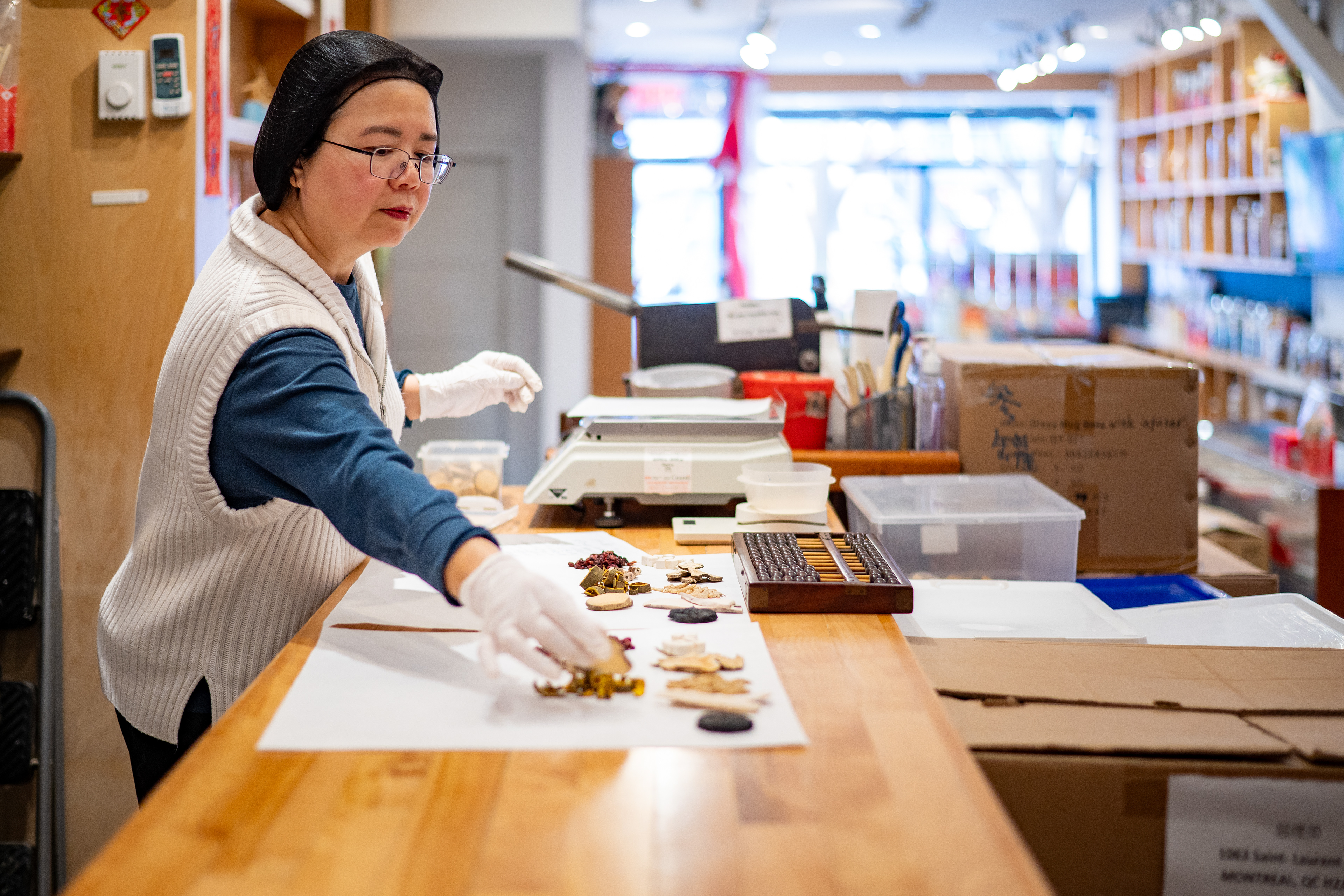 He Yu Shan, herboriste du magasin, prépare les commandes.  He Yu Shan, store herbalist, prepares orders  店裡的中草藥劑師何玉珊在抓藥方