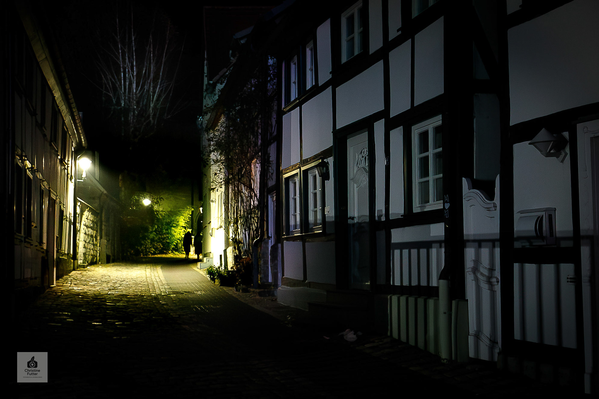 In Soest bringen wenige Schritte den Kirmesbesucher weg vom überwältigenden Trubel der Kirmes in eine Lichtstimmung fast wie im Mittelalter. So wie dieses Paar, das sich durch eine Gasse mit Fachwerkhäusern vom Betrachter entfernt. . [Soest 2023]