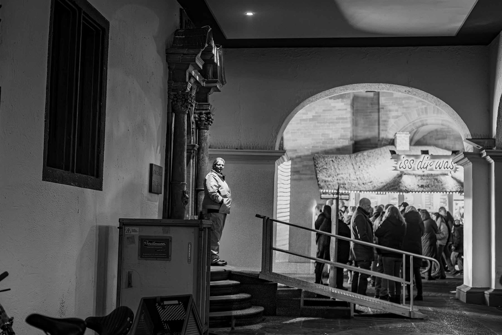 Der mittelalterliche Torbogen des Blauen Saales trennt Welten. Draußen laut und bunt, drinnen Ruhe. Draußen Bullenauge, drinnen Kaffee für die lange Nacht. Vor der Tür Hot Dogs, in der Kantine Grünkohl mit Mettwürstchen. Nur selten beachten die Besucher der Kirmes die Menschen, die zu ihrem Schutz auf viele Stunden Freizeit verzichten, in denen sie Dinge tun könnten, die viel weniger anstrengend sind, als zehn Stunden Sanitätsdienst auf der Allerheiligenkirmes. Für den Ernstfall aber stehen sie bereit. 