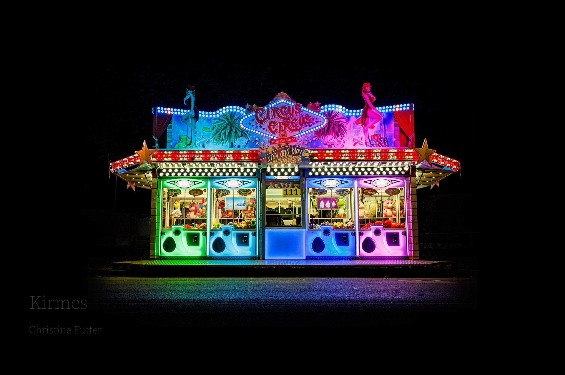 2:00 Uhr in der Nacht. Eine grell bunt illuminierte Spielbude schwebt fast vor dem pechschwarzen Hintergrund. Die Abwesenheit von Menschen macht die Szene surreal und verleiht ihr sowohl etwas bedrohliches, als auch eine verlassene Traurigkeit. [Soest 2024]