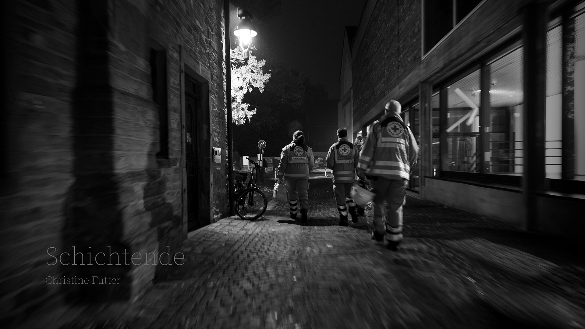 Schichtende auf der Allerheiligenkirmes in Soest. Eine Gruppe Sanitäter*innen geht durch die dunklen Gassen zum wartenden Mannschaftfahrzeug.