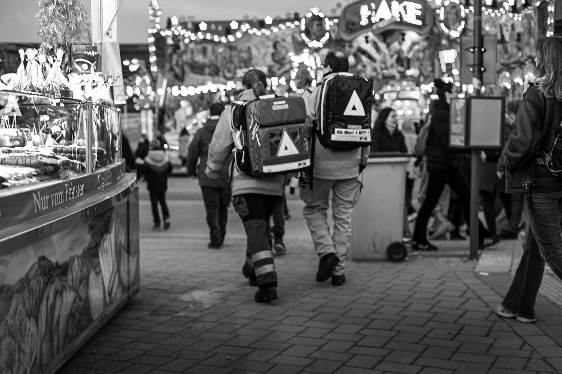 Dieses Erstversorgungsteam - kurz EVT - ist zu Fuß auf der Soester Kirmes unterwegs. In den Rucksäcken haben sie das nötigste Material für die Erstversorgung von Verletzten zur Hand. Die Schichten können lang sein. Manche Kollegen und Kolleginnen patrouillieren bis zu fünf Tage über die Kirmes und nehmen dafür sogar Urlaub. Fuß-Aua ist da garantiert.