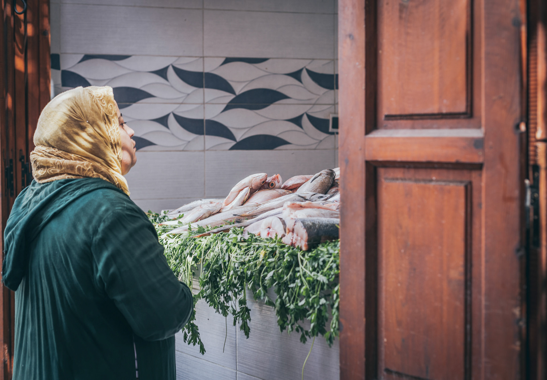 Una donna al mercato per comprare del pesce
