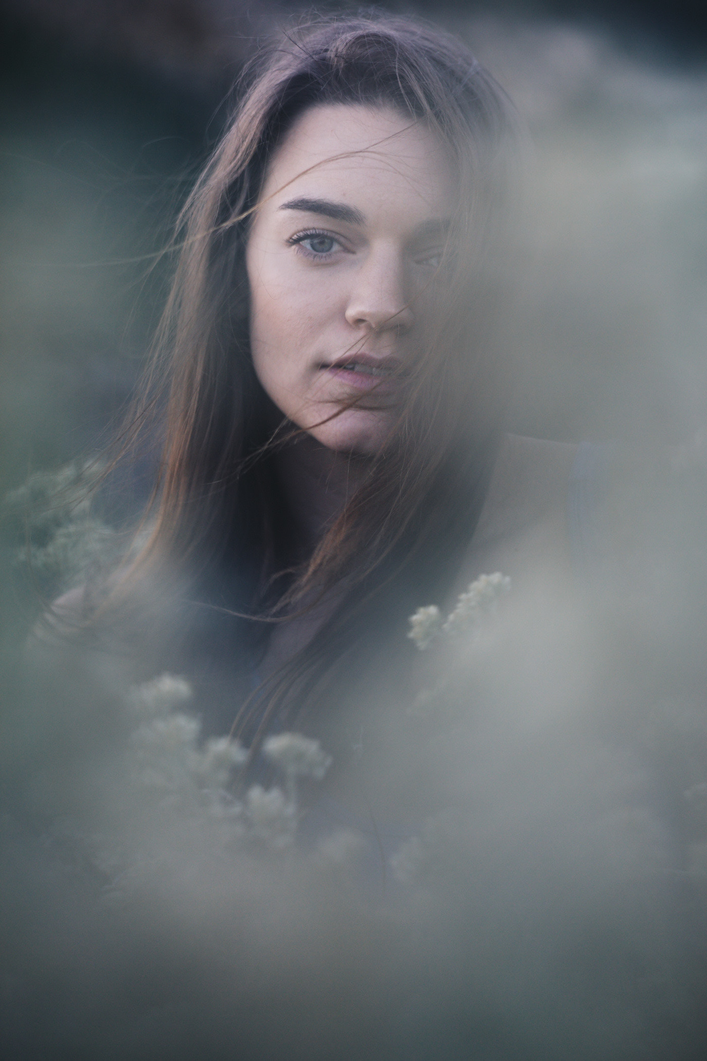 Portrait through flowers of a beautiful woman.  Photo by Modern Human