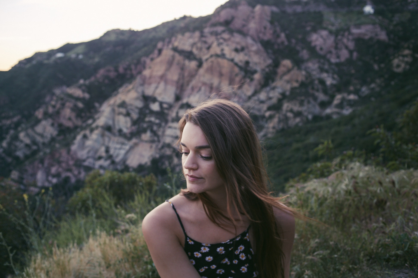 Beautiful woman contemplates her life.  In front of a mountain.  Photo by Modern Human