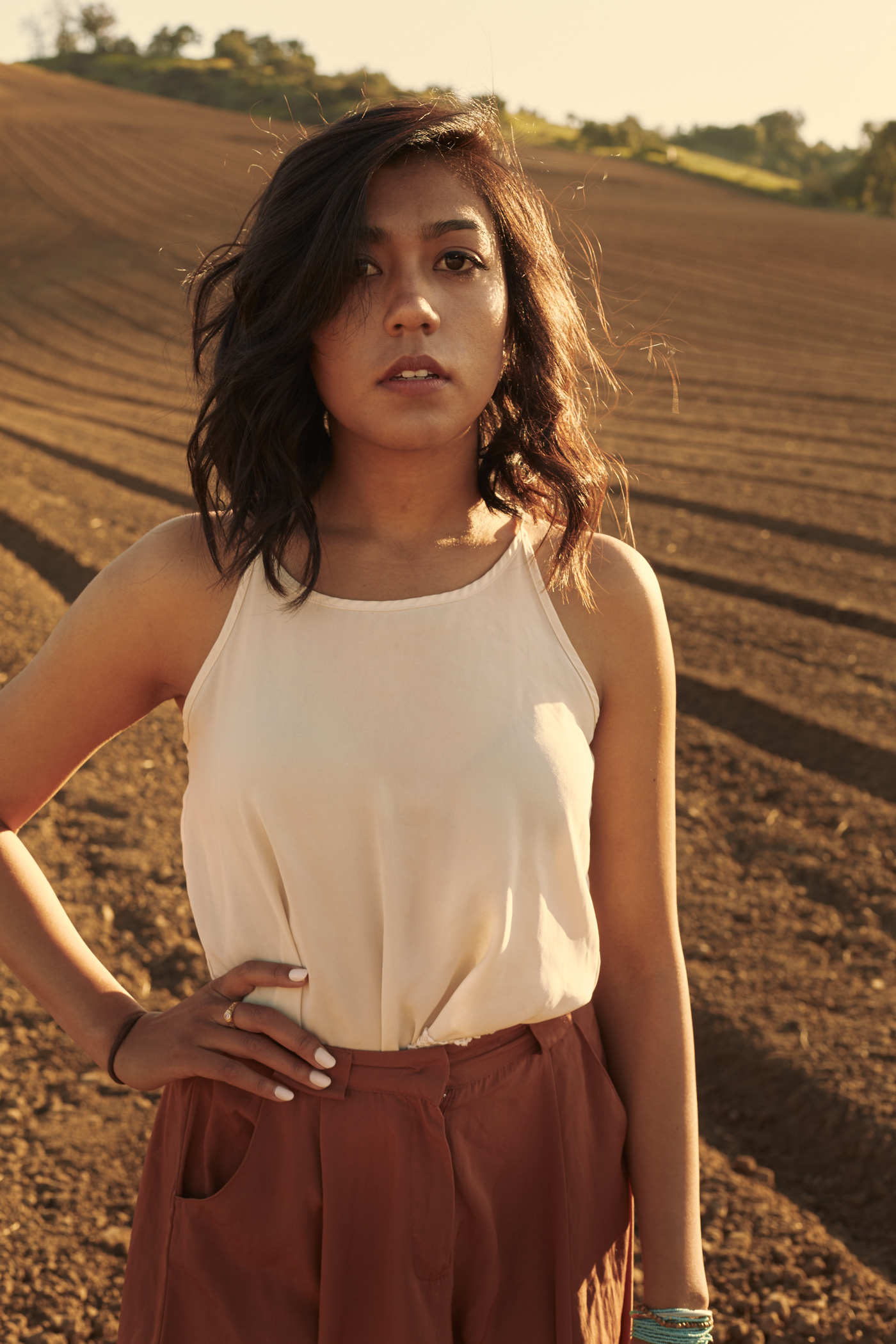 Beautiful girl standing in field.  Photo by Modern Human
