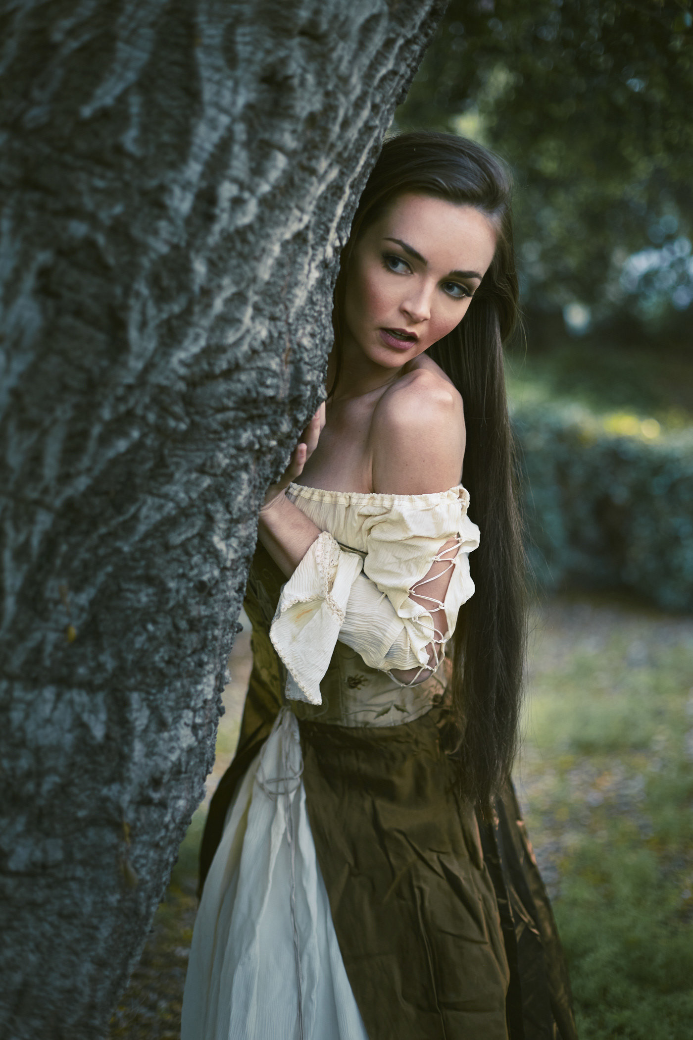 Beautiful girl coming around a tree.  Photo by Modern Human
