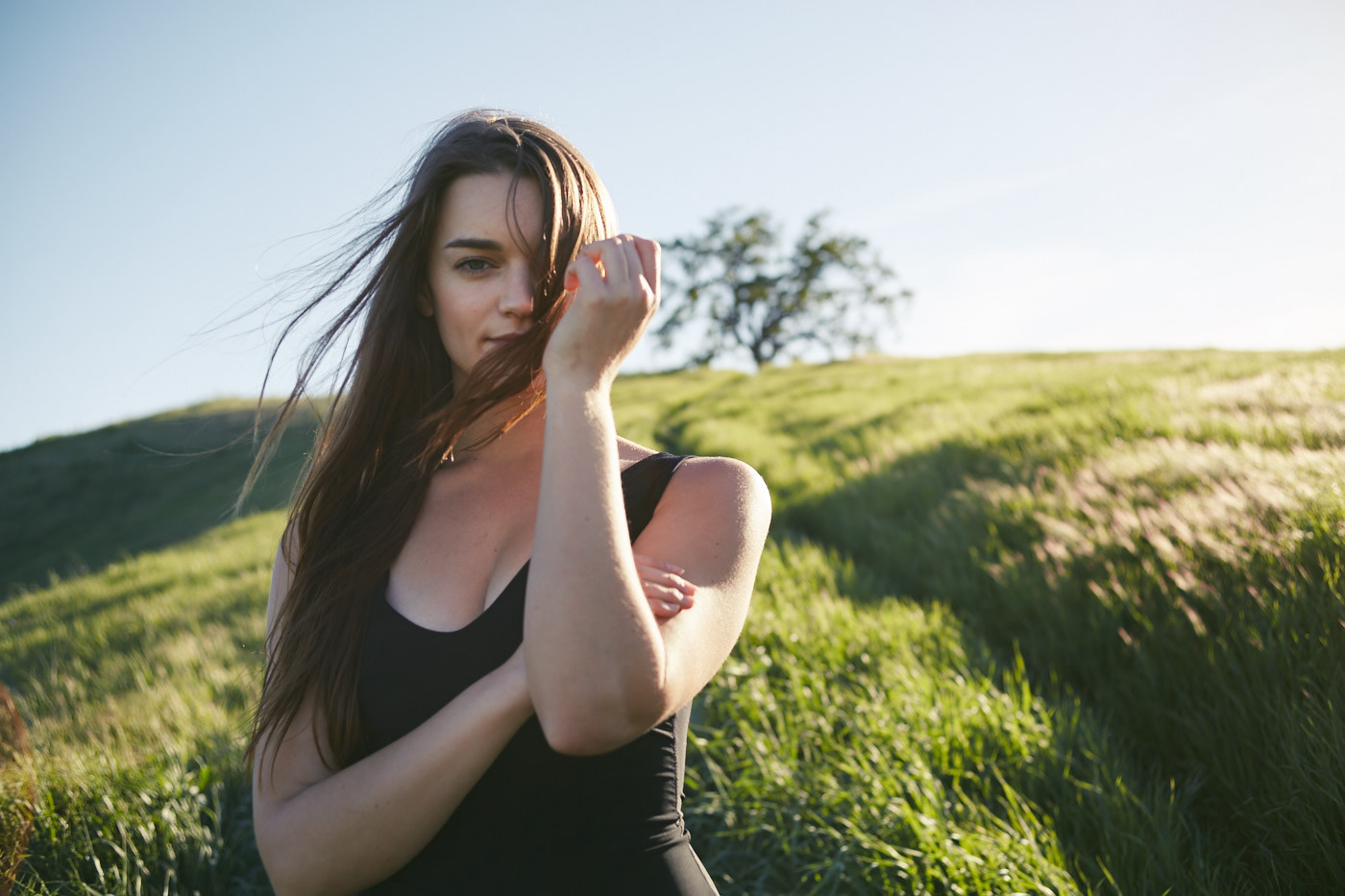 Beautiful woman walking rolling hills.  Wind blowing. Photo by Modern Human