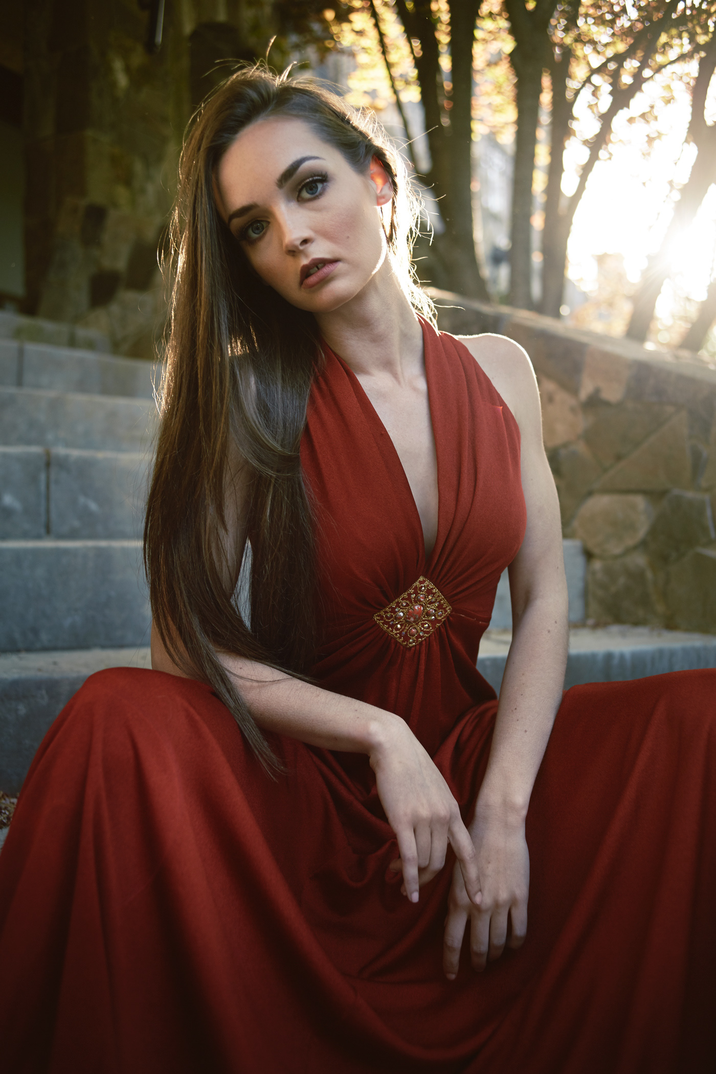 Beautiful girl on stone staircase, in a red dress..  Photo by Modern Human