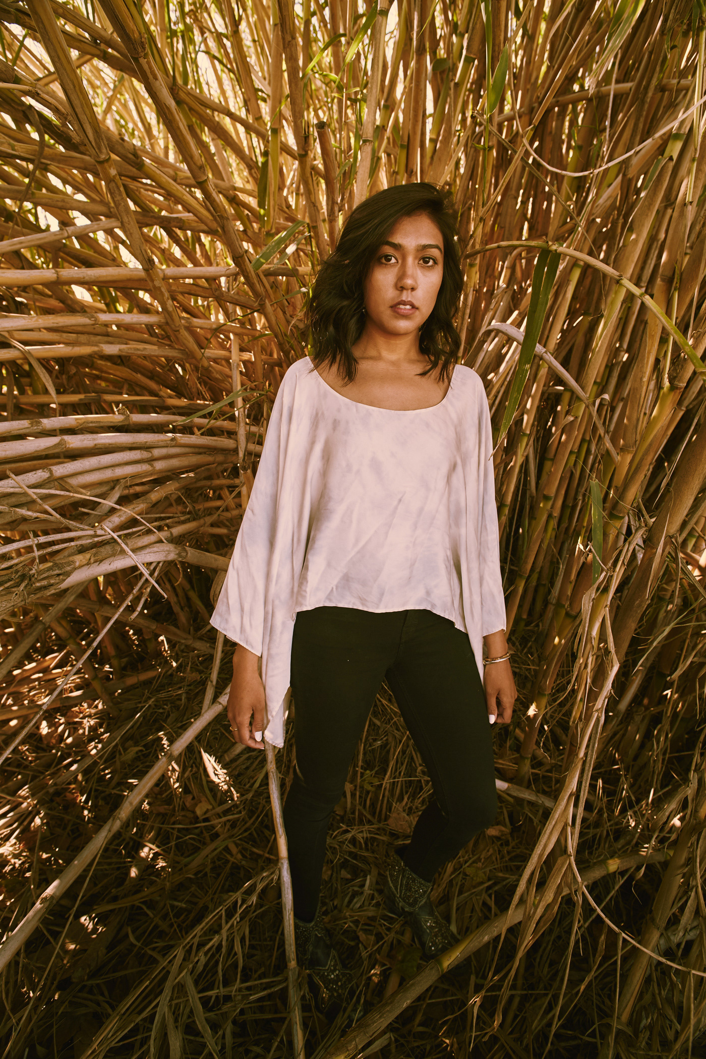 Beautiful girl standing amongst bamboo.  Photo by Modern Human
