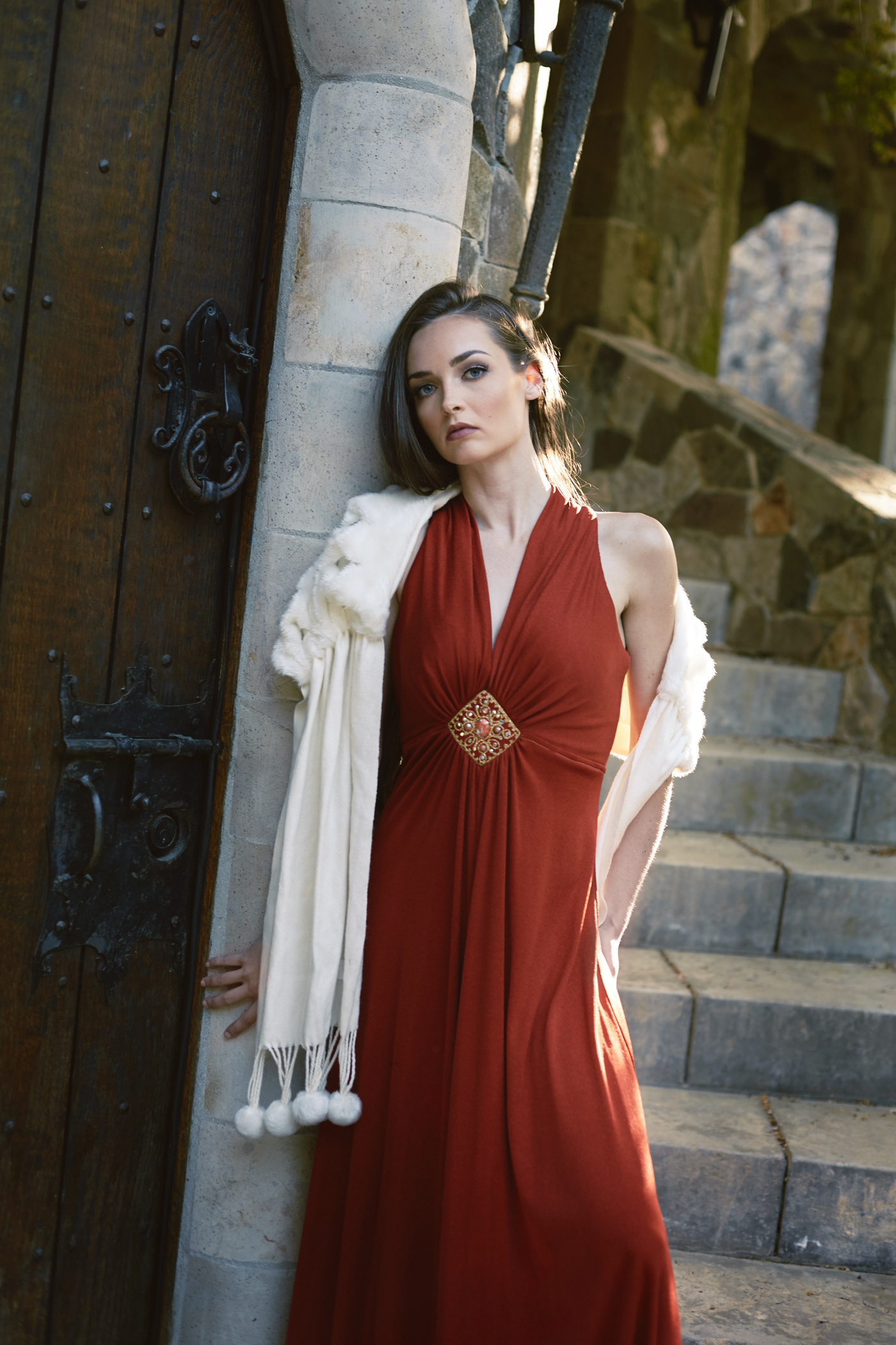 Beautiful at castle entrance, in a red dress.  Photo by Modern Human
