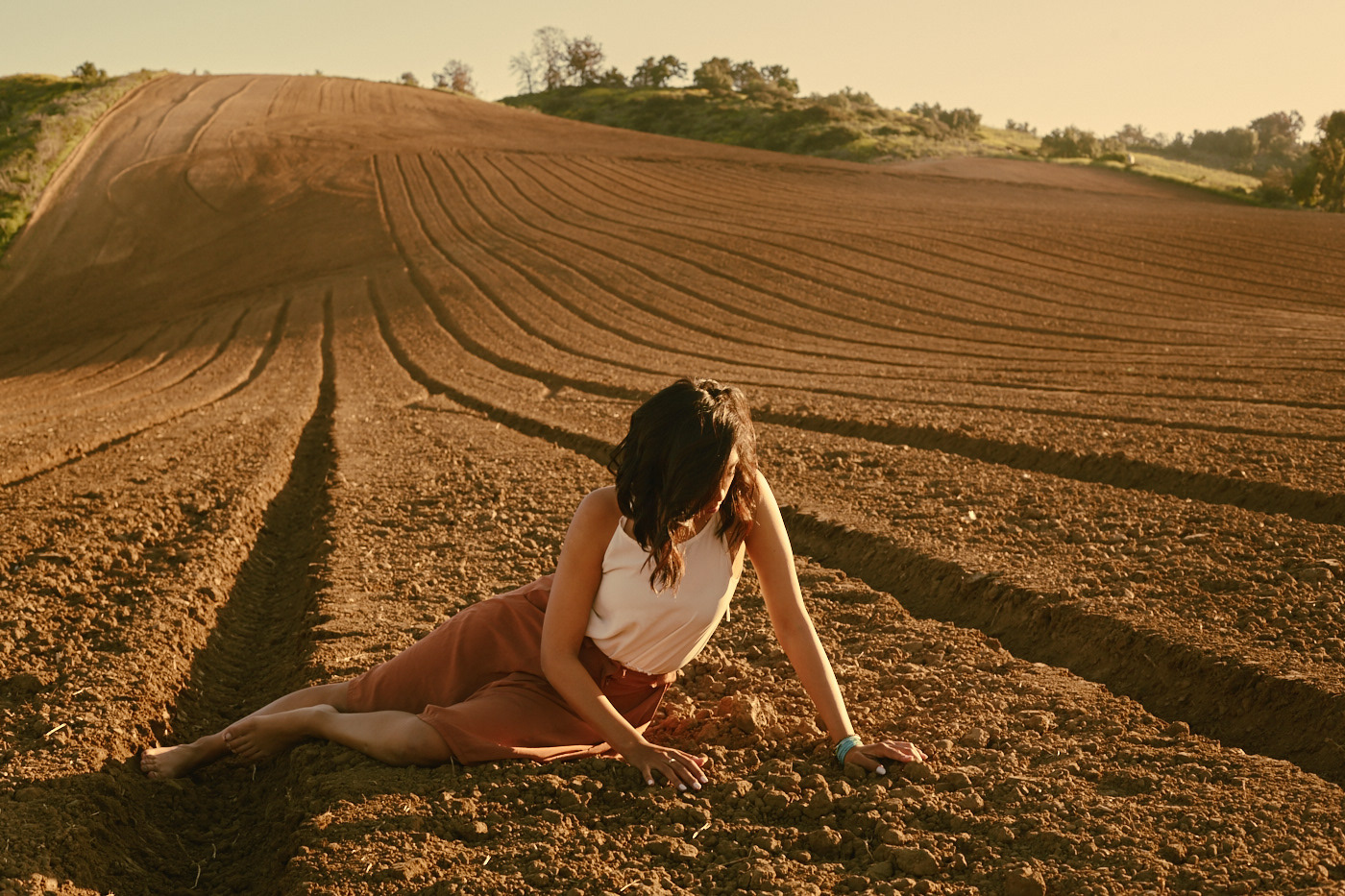 Beautiful girl lying in field.  Photo by Modern Human