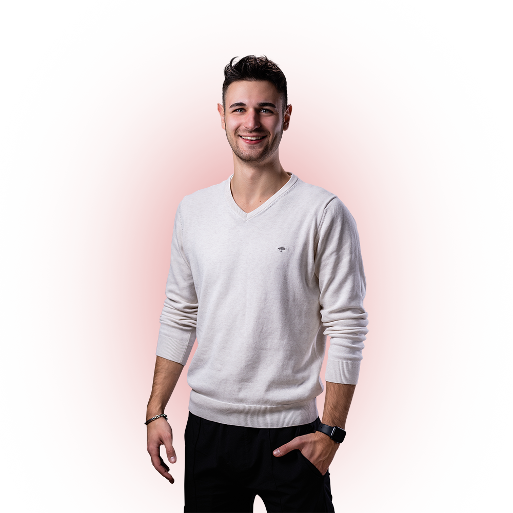 Ein junger Mann mit kurzem, braunem Haar trägt einen hellen Pullover und lächelt in die Kamera. Er hat die Hände entspannt an den Seiten, trägt ein Armband am linken Handgelenk und eine Armbanduhr am rechten Handgelenk. Der Hintergrund ist transparent.