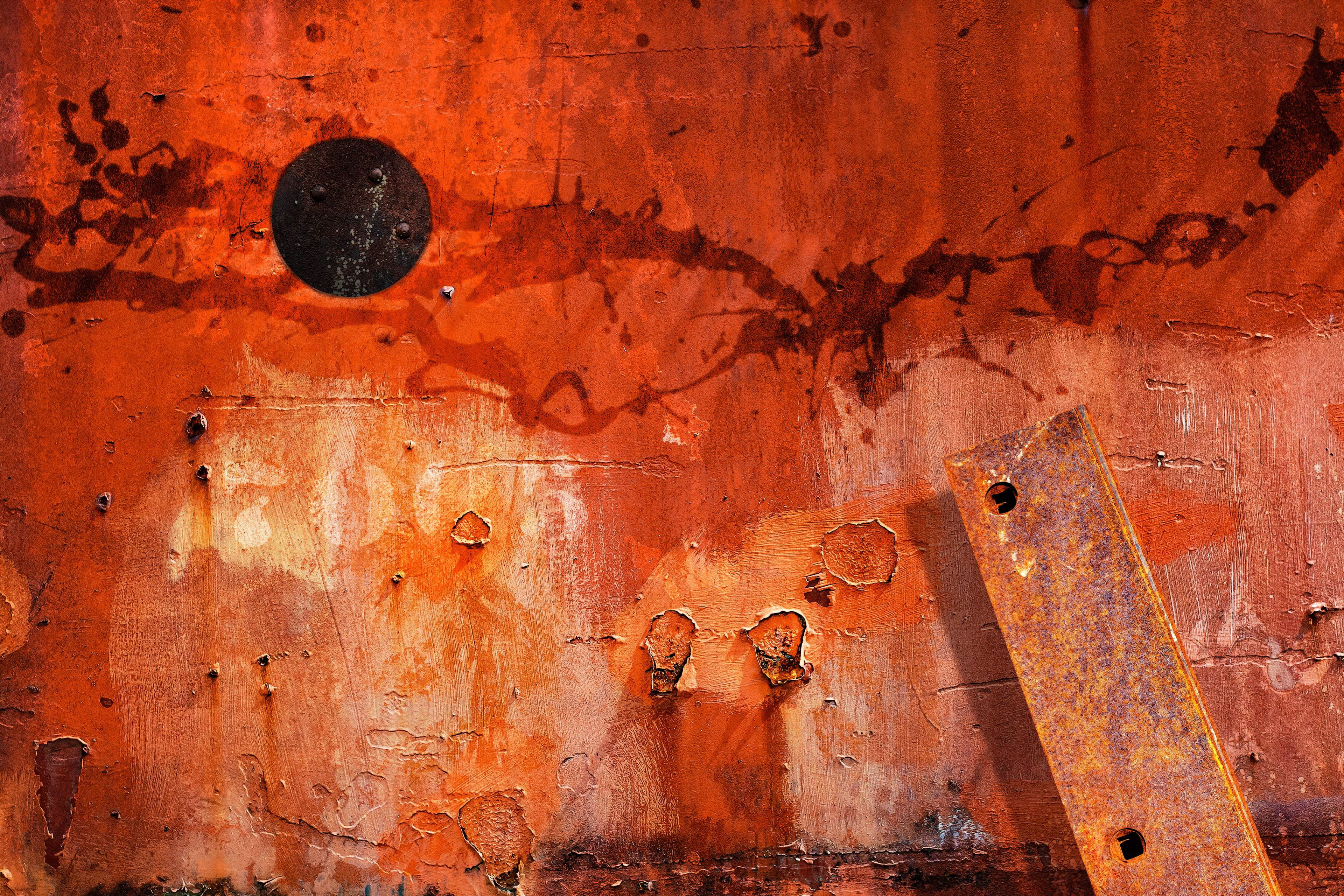 Abstract image of brightly colored orange and red colored rusted iron slab with peeling paint