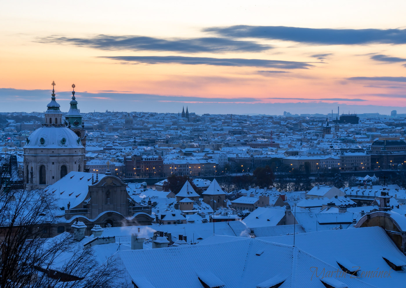 Výhled z Hradčanského náměstí na zasněžené malostranské střechy 