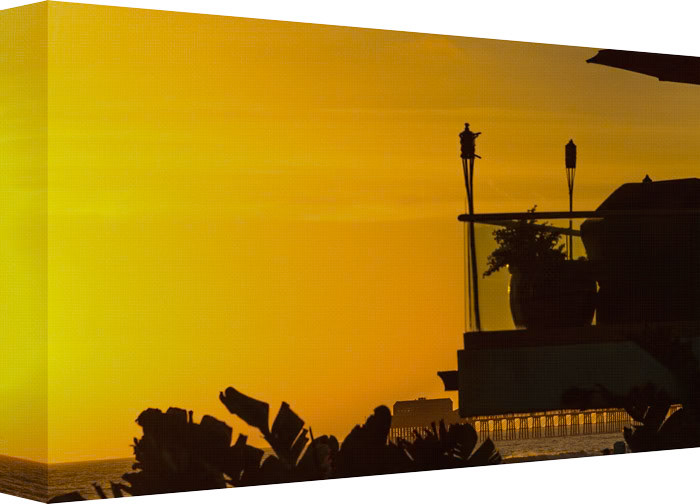 You’re watching as the Sun sets into the Pacific Ocean, while lighting the skies and the distance pier with its Fire glow.