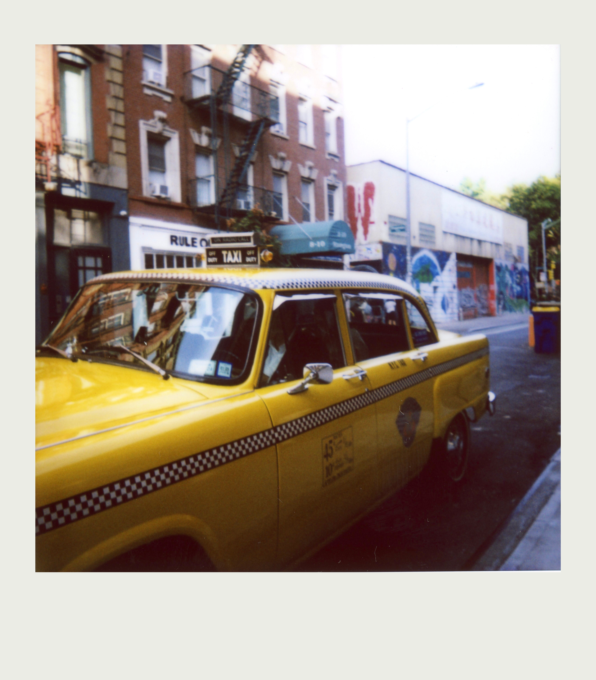 Square Instax photo of Old style New York Taxi with Newlyweds.