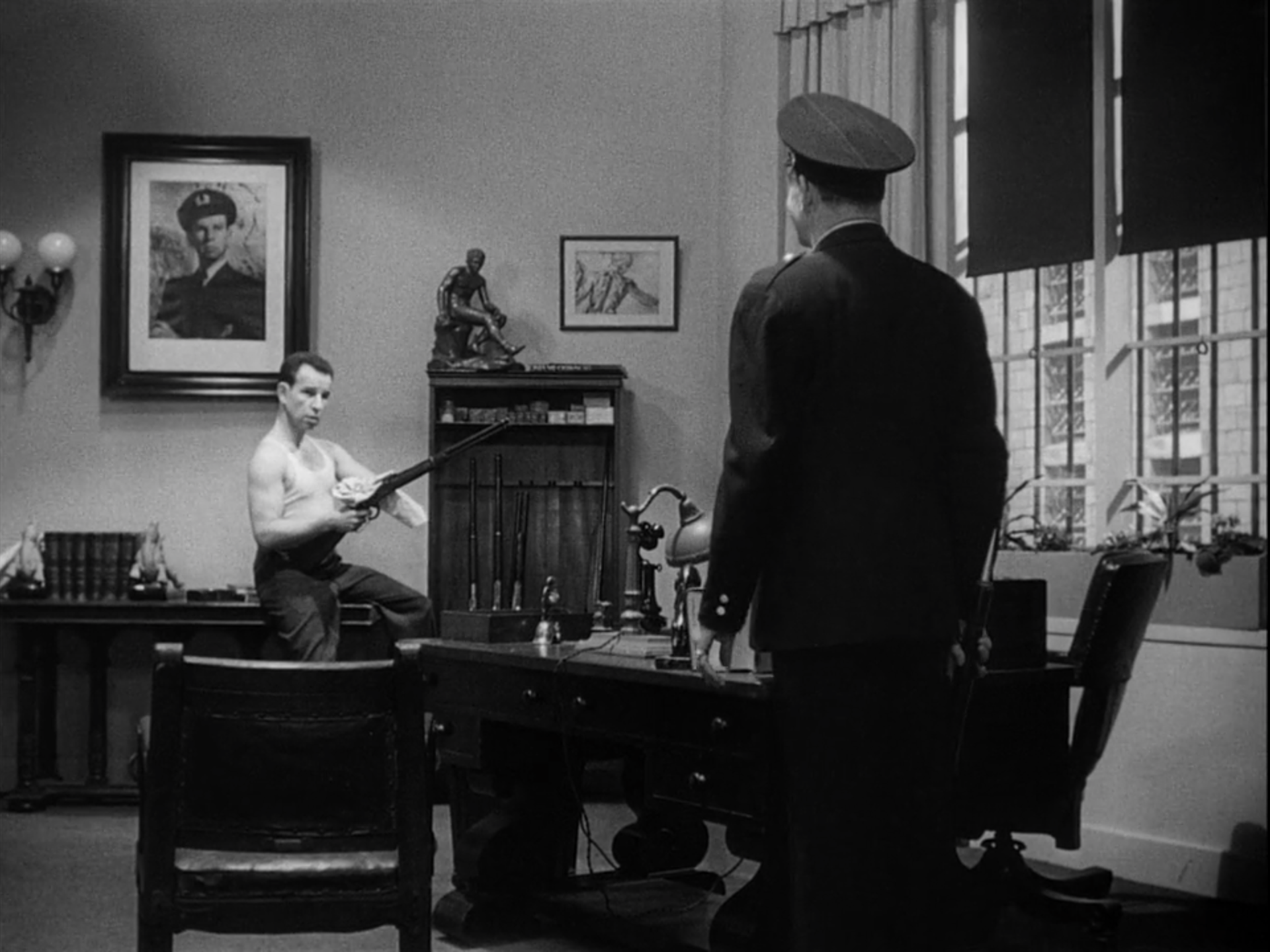 Munsey's office, with the captain mirroring the statue on his bookshelf.