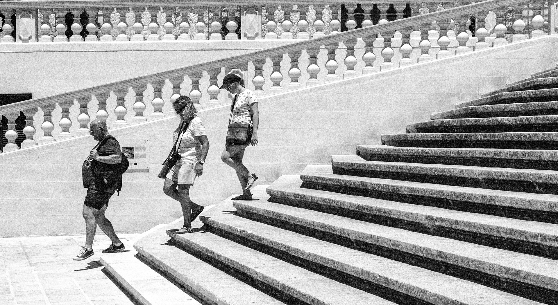 Three people walking down steps Gozo, Malta