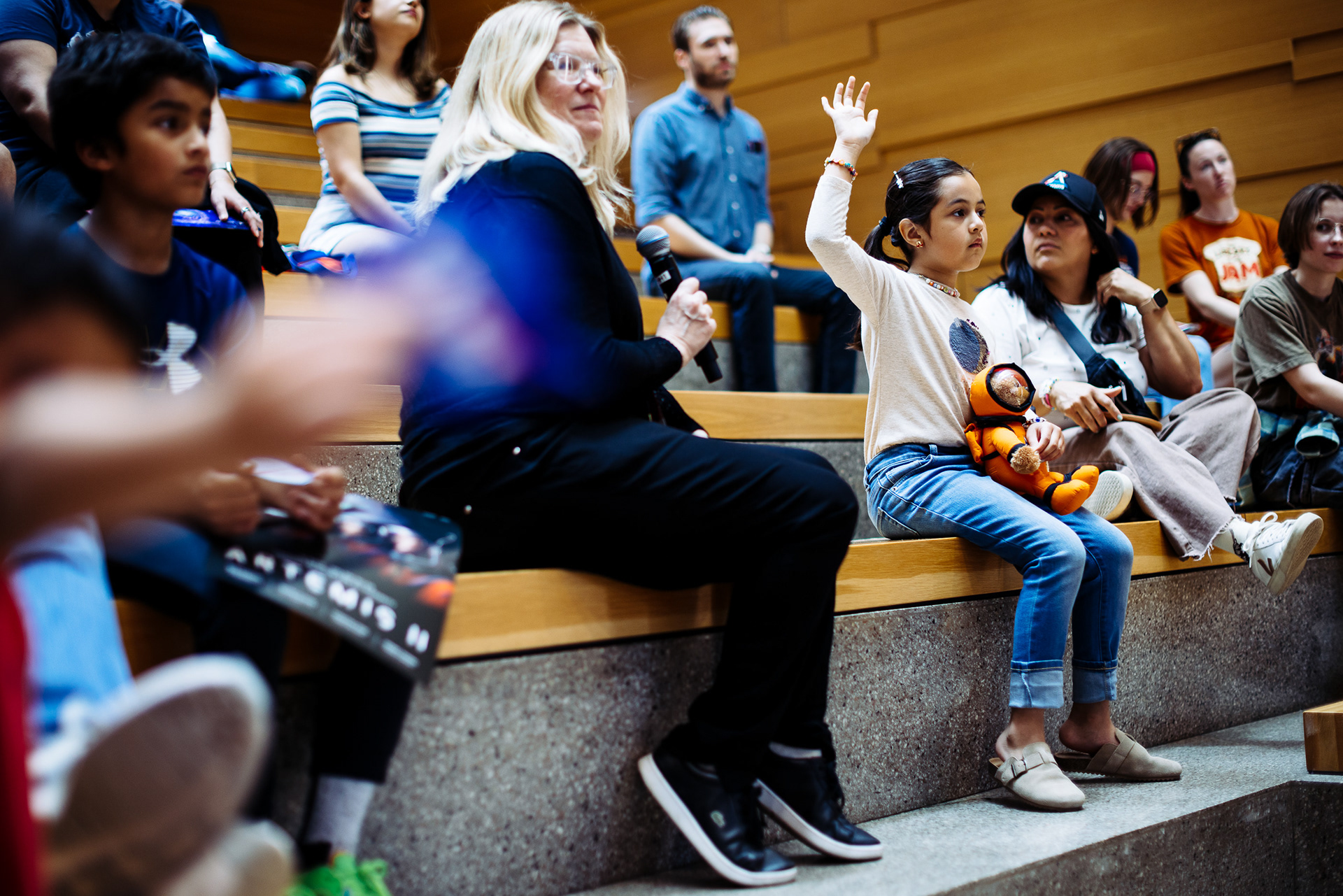 Audience seated on tiered benches during an event talk