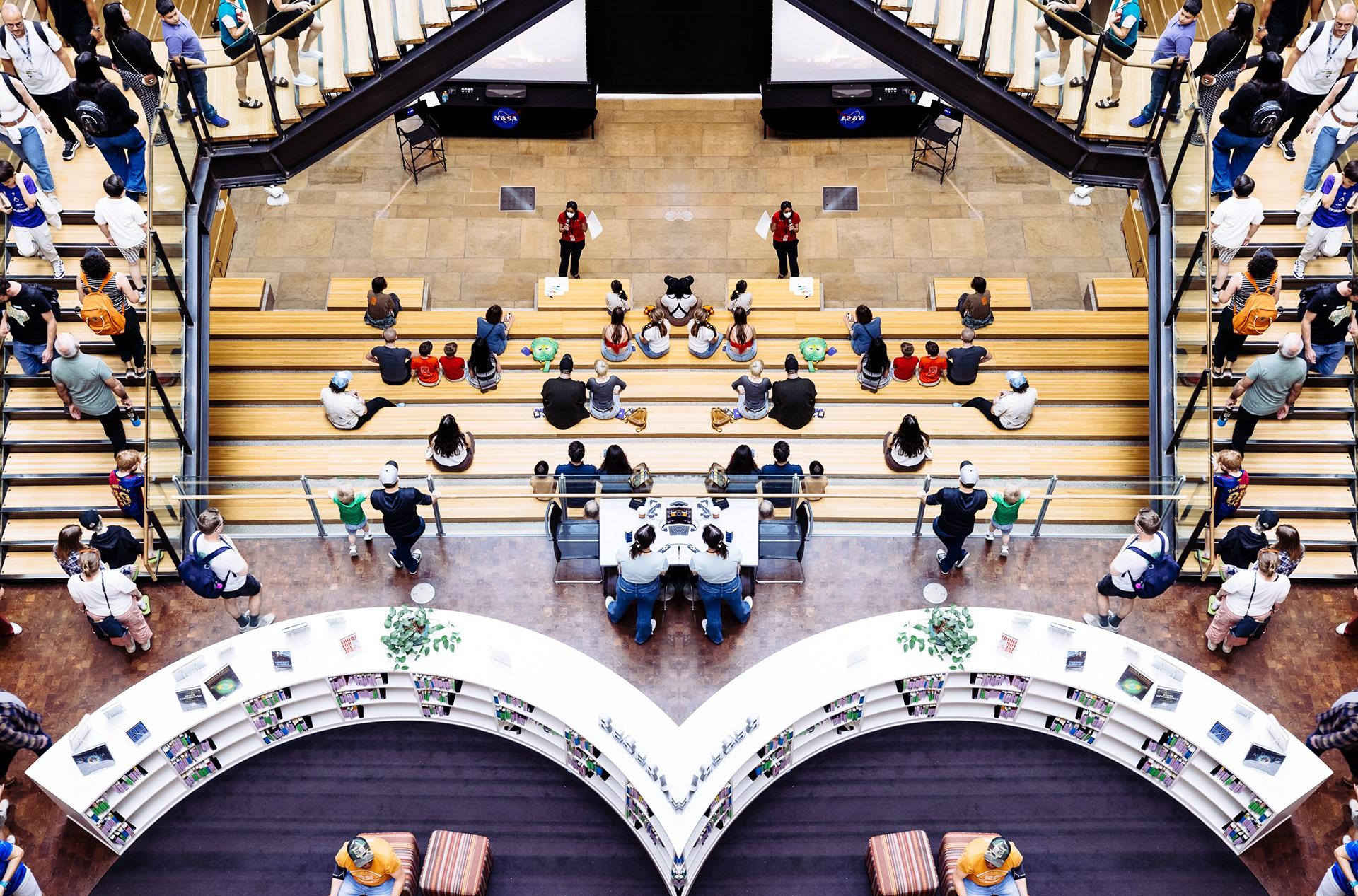 Overhead view of tiered auditorium seating in a mirrored composition